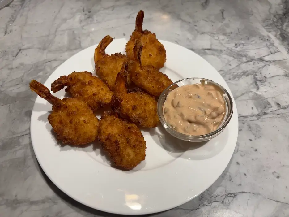 Breaded shrimp on plate with light orange sauce