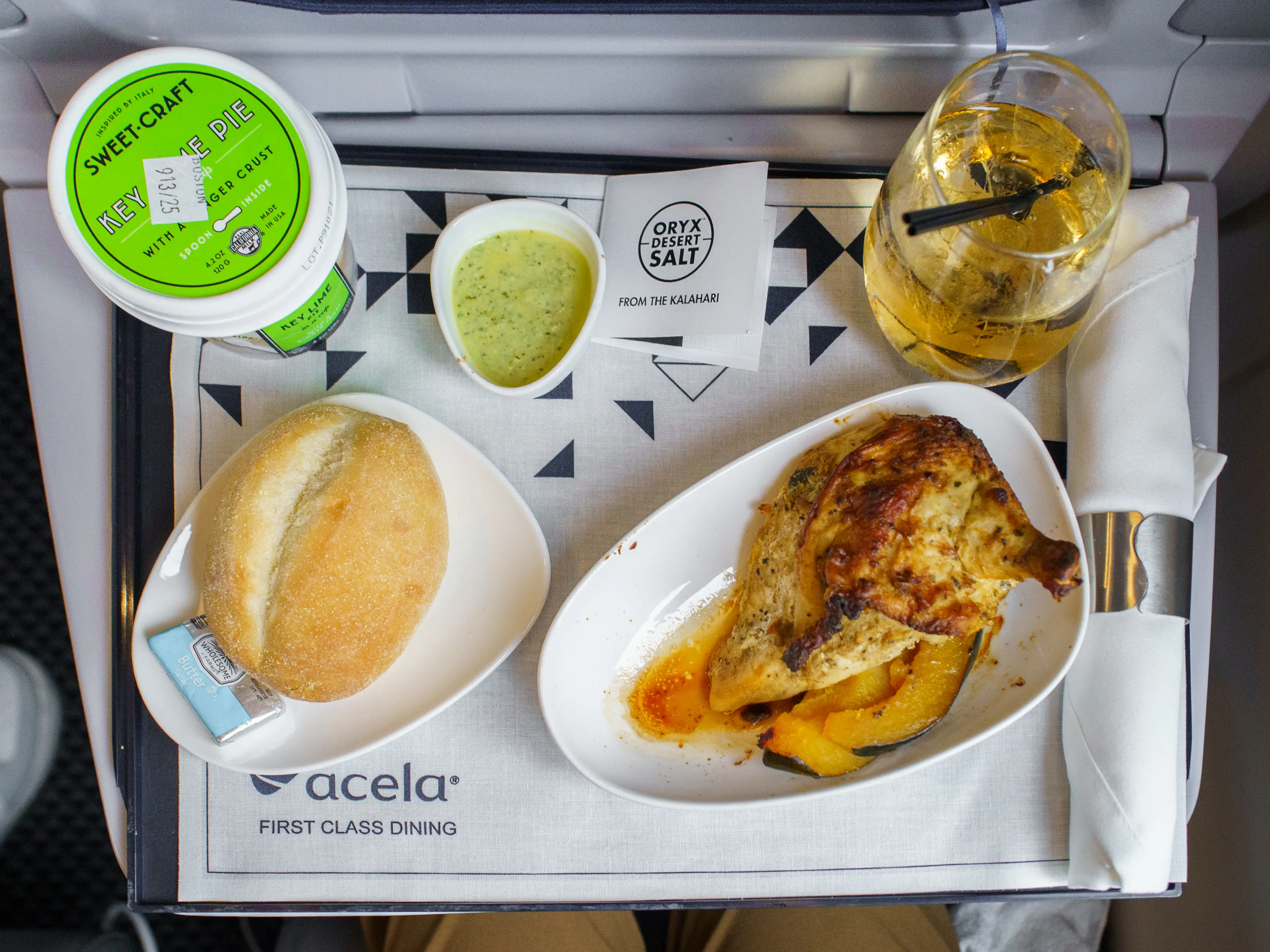 An aerial view of the author's meal on a train, including chicken and sides