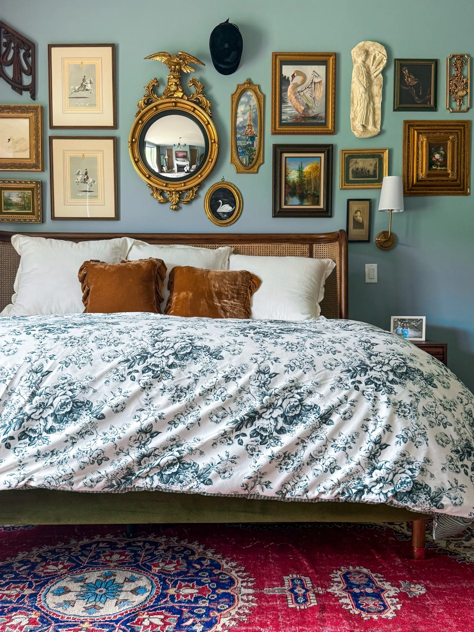 A bedroom with a large bed and a gallery wall.