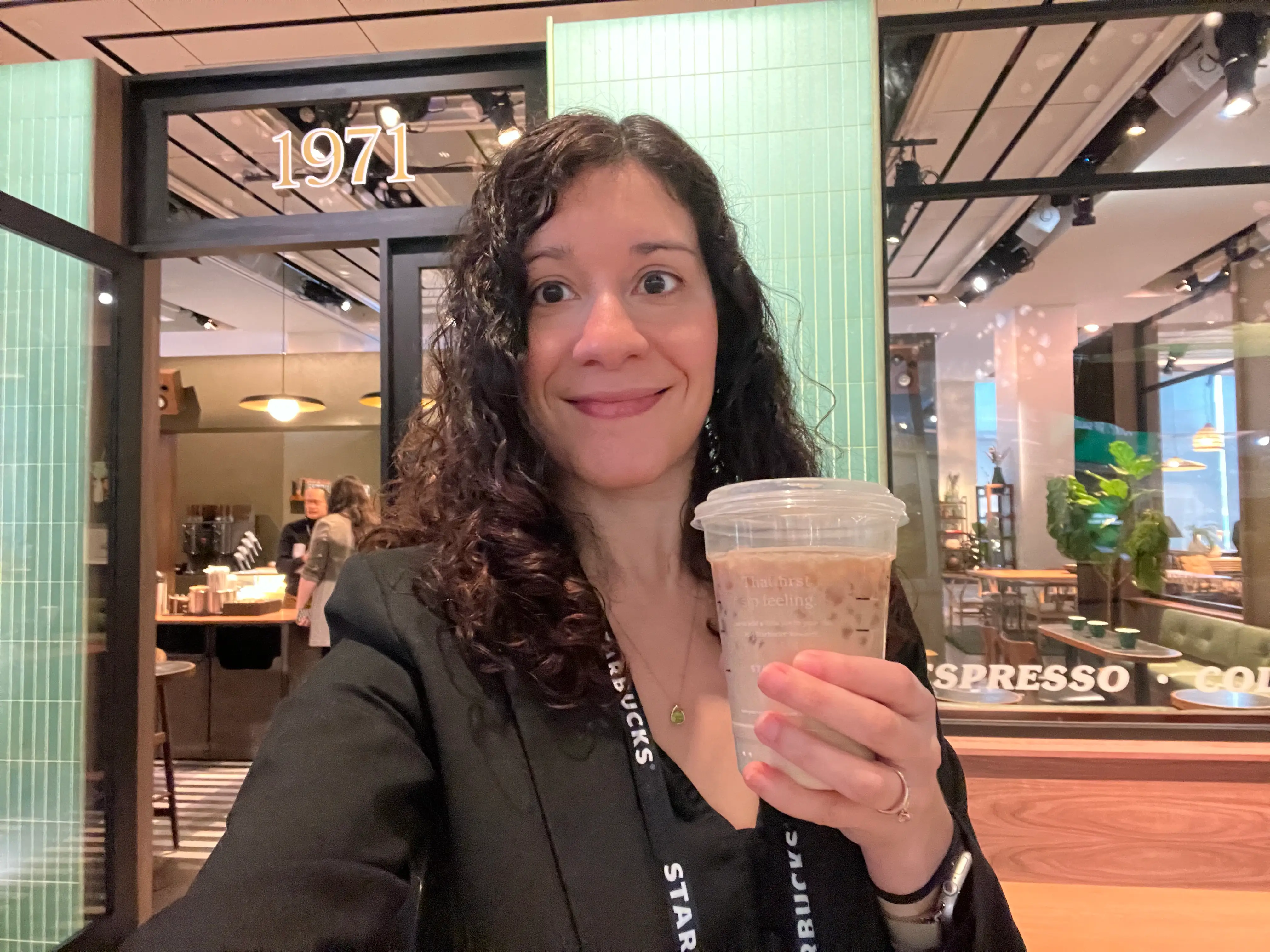 Business Insider reporter Ashley Rodriguez takes a selfie holding a cold brew in front of Starbucks' new coffeehouse model.