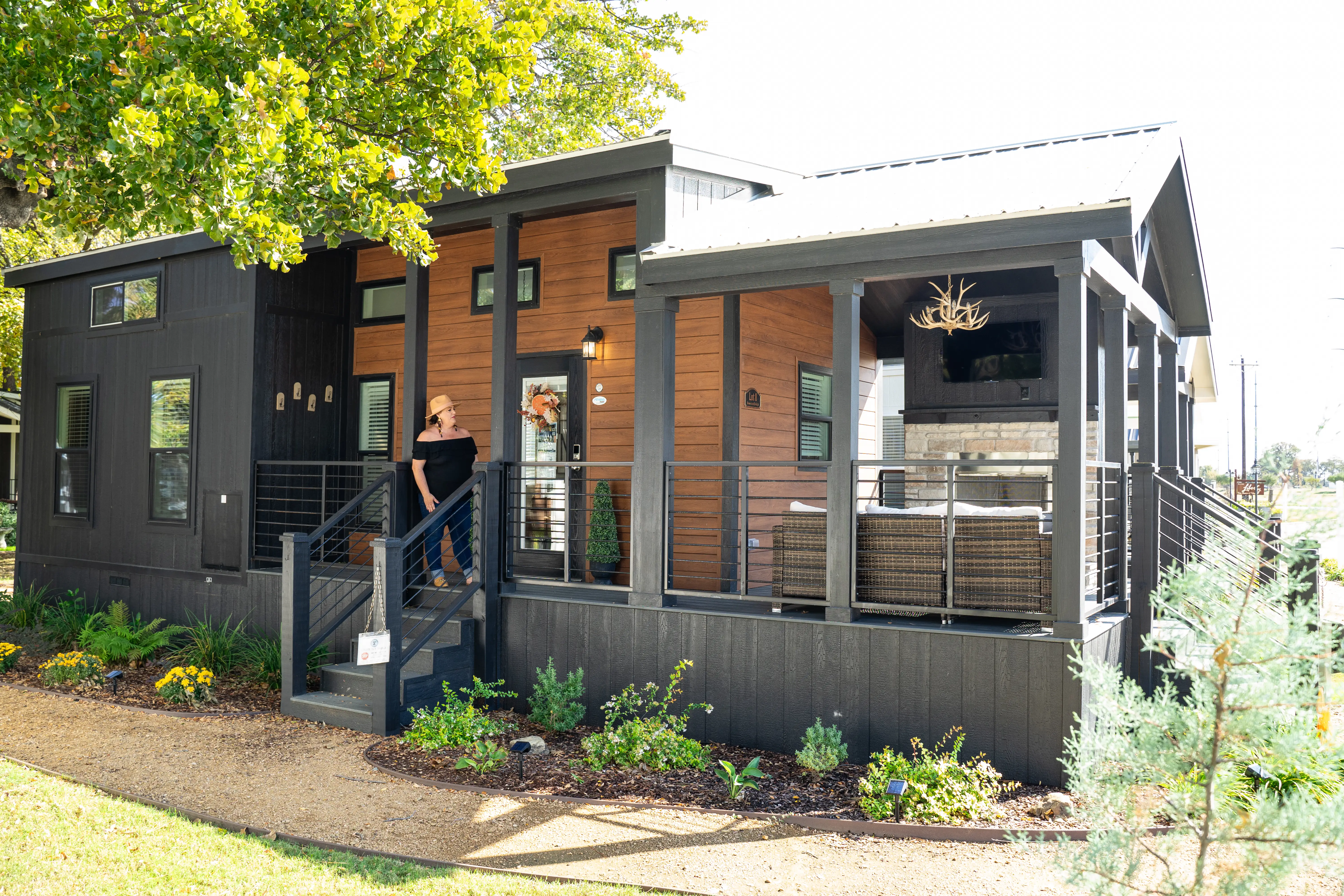 A woman standing on the stairs of a tiny home.