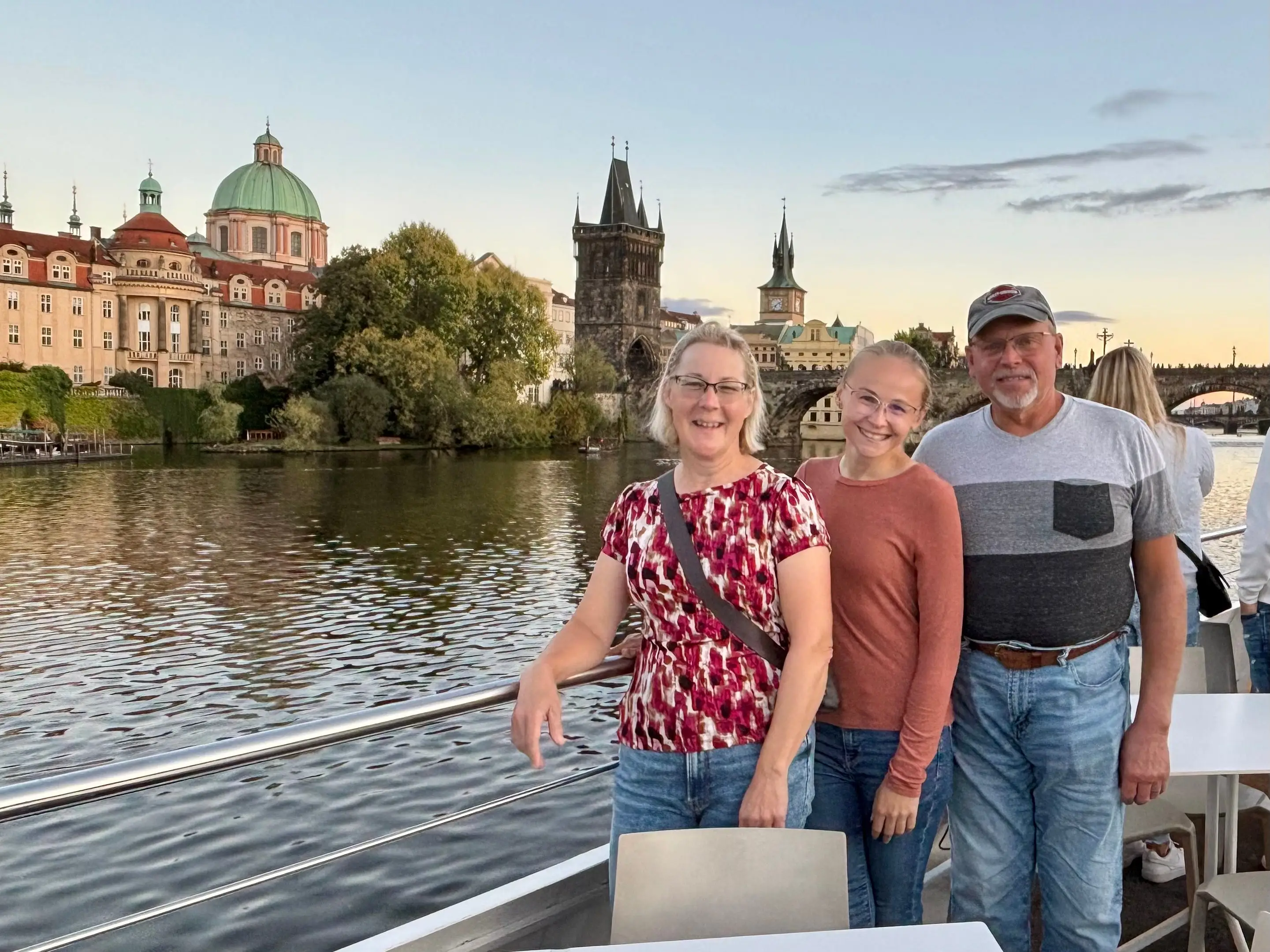 The author and her parents posing on a boat in Prague.
