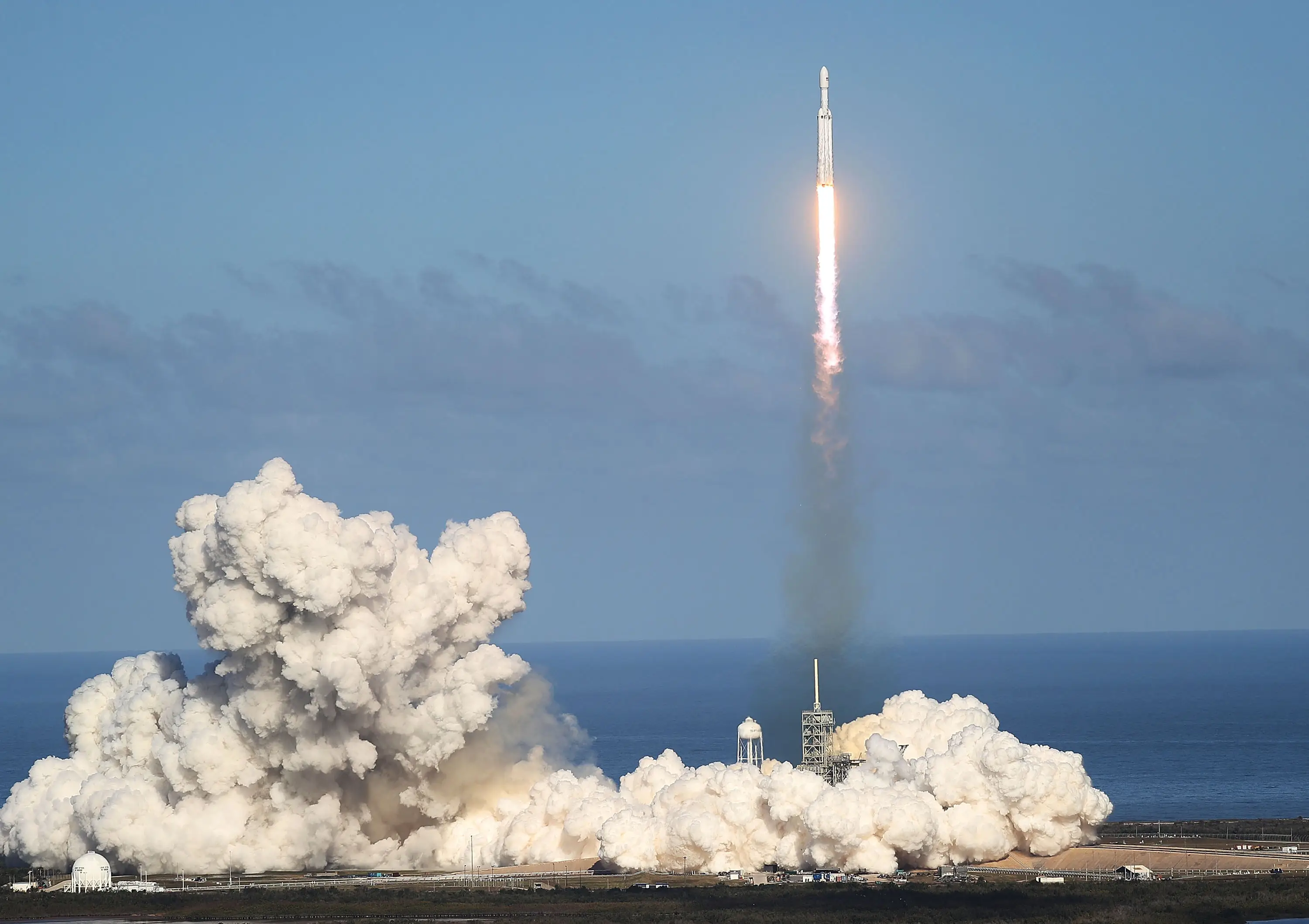 A Falcon Heavy rocket from SpaceX takes off from a launch pad in Florida during a clear day.
