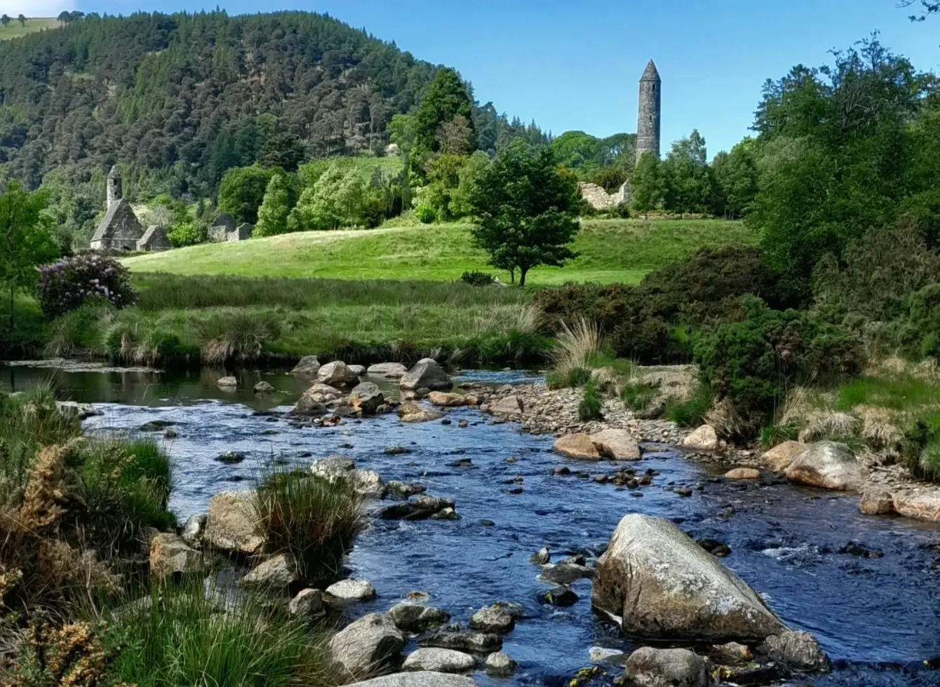 A creek with trees, rocks, and hills near Glendalough Monastic Site in Ireland.