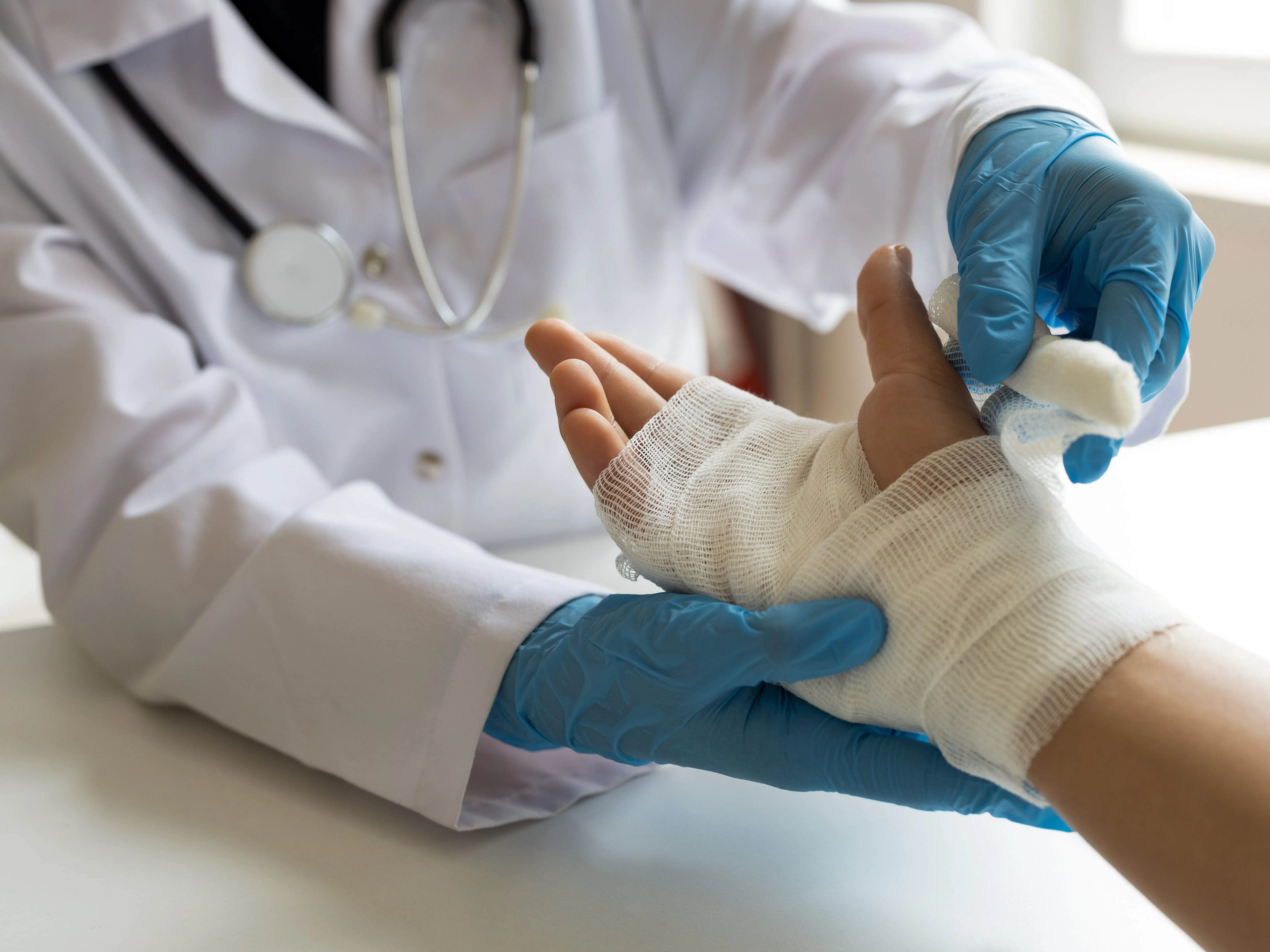 a doctor wrapping a patients hand in bandage
