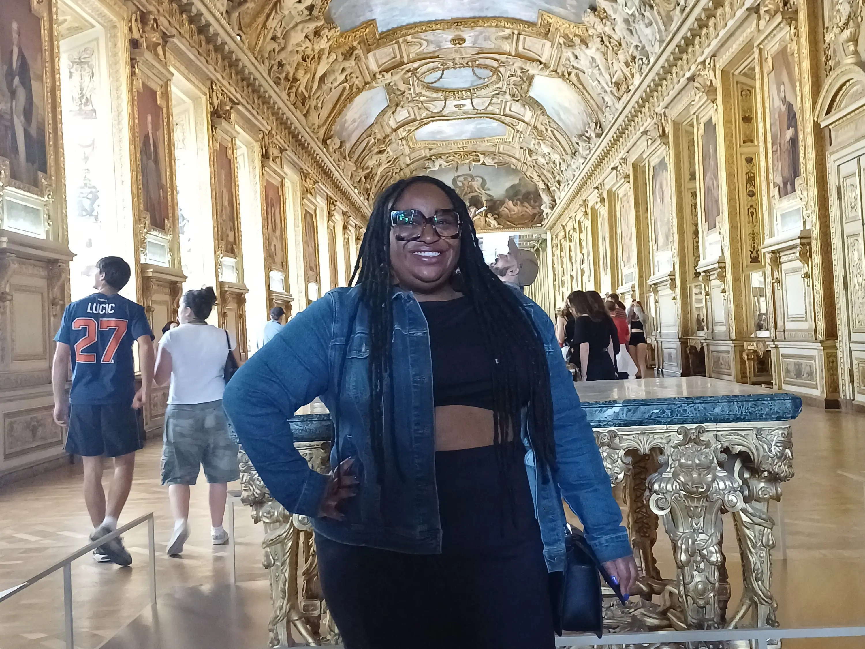 Woman smiling inside building with gilded ceiling