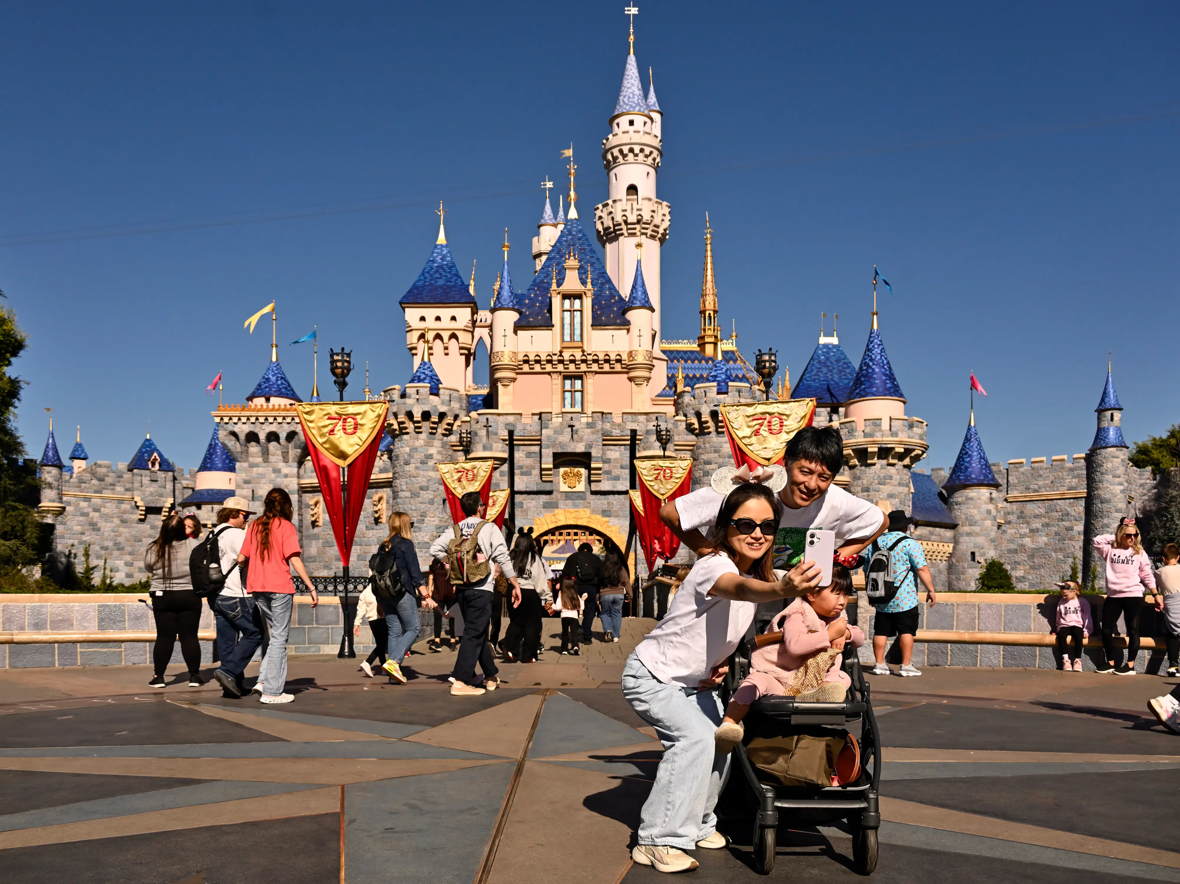 Visitors take a selfie at Sleeping Beauty Castle inside Disneyland at the Disneyland Resort.