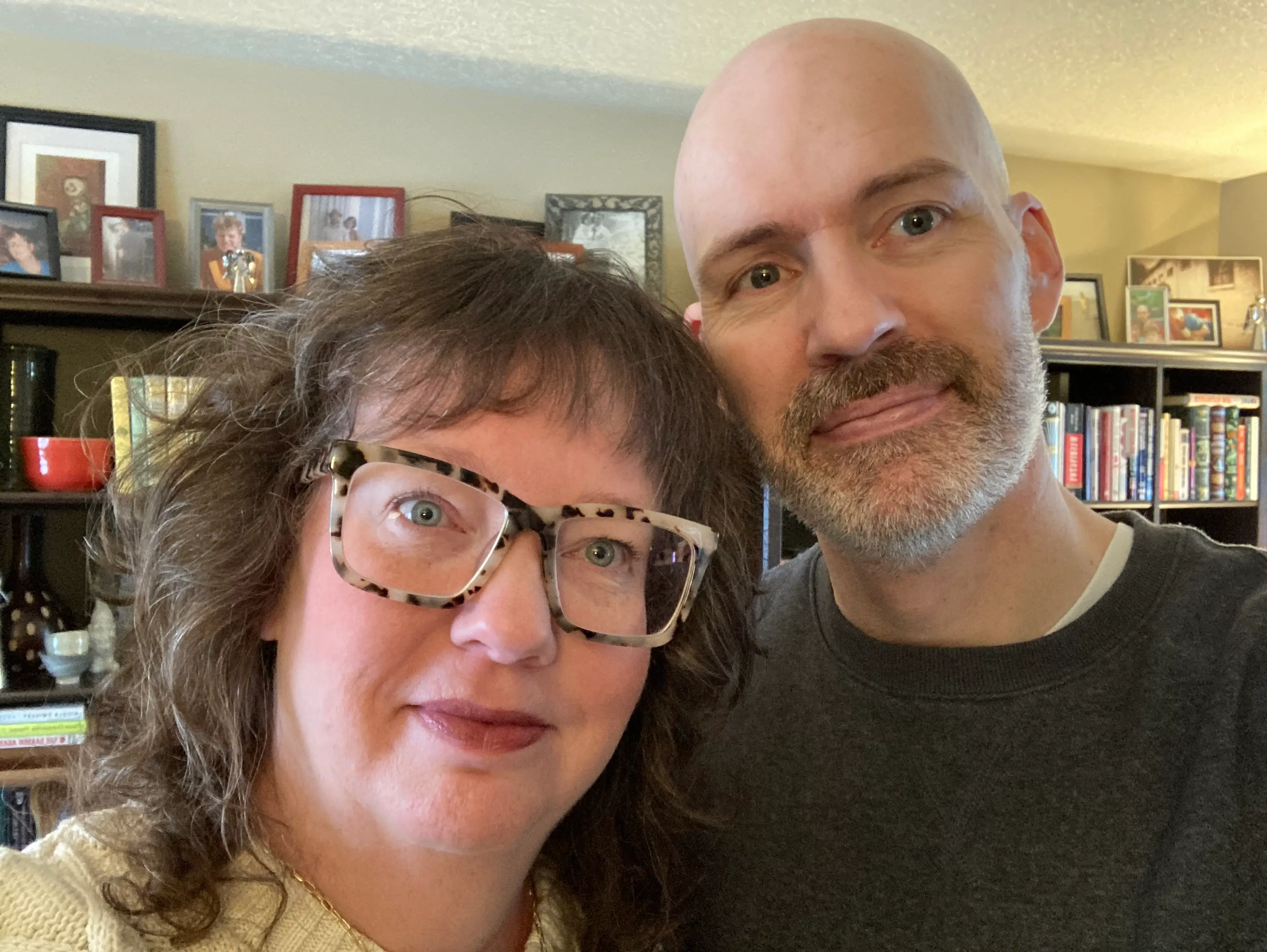 Woman and man smiling in front of bookshelves