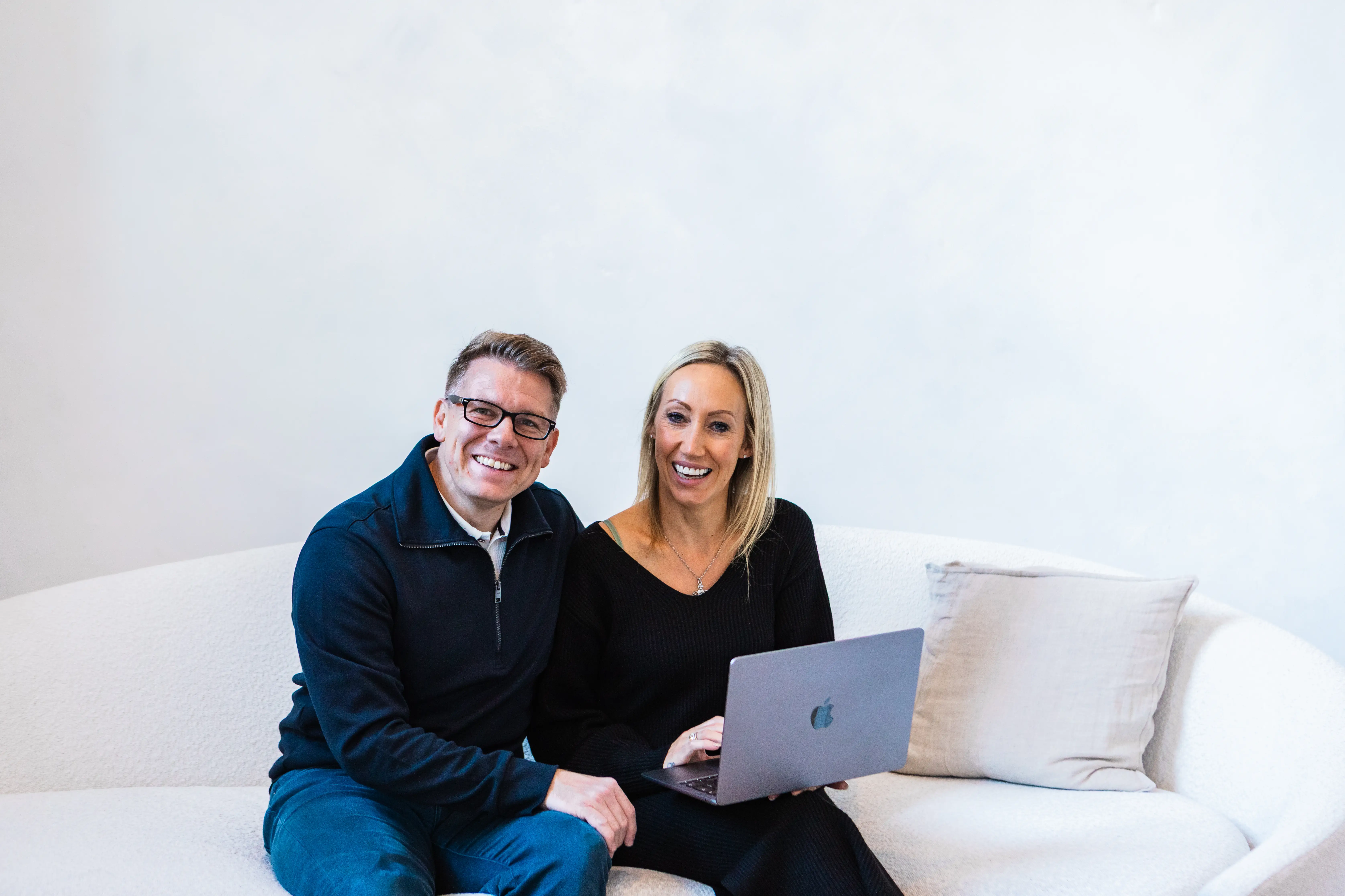 Couple posing for photo with laptop