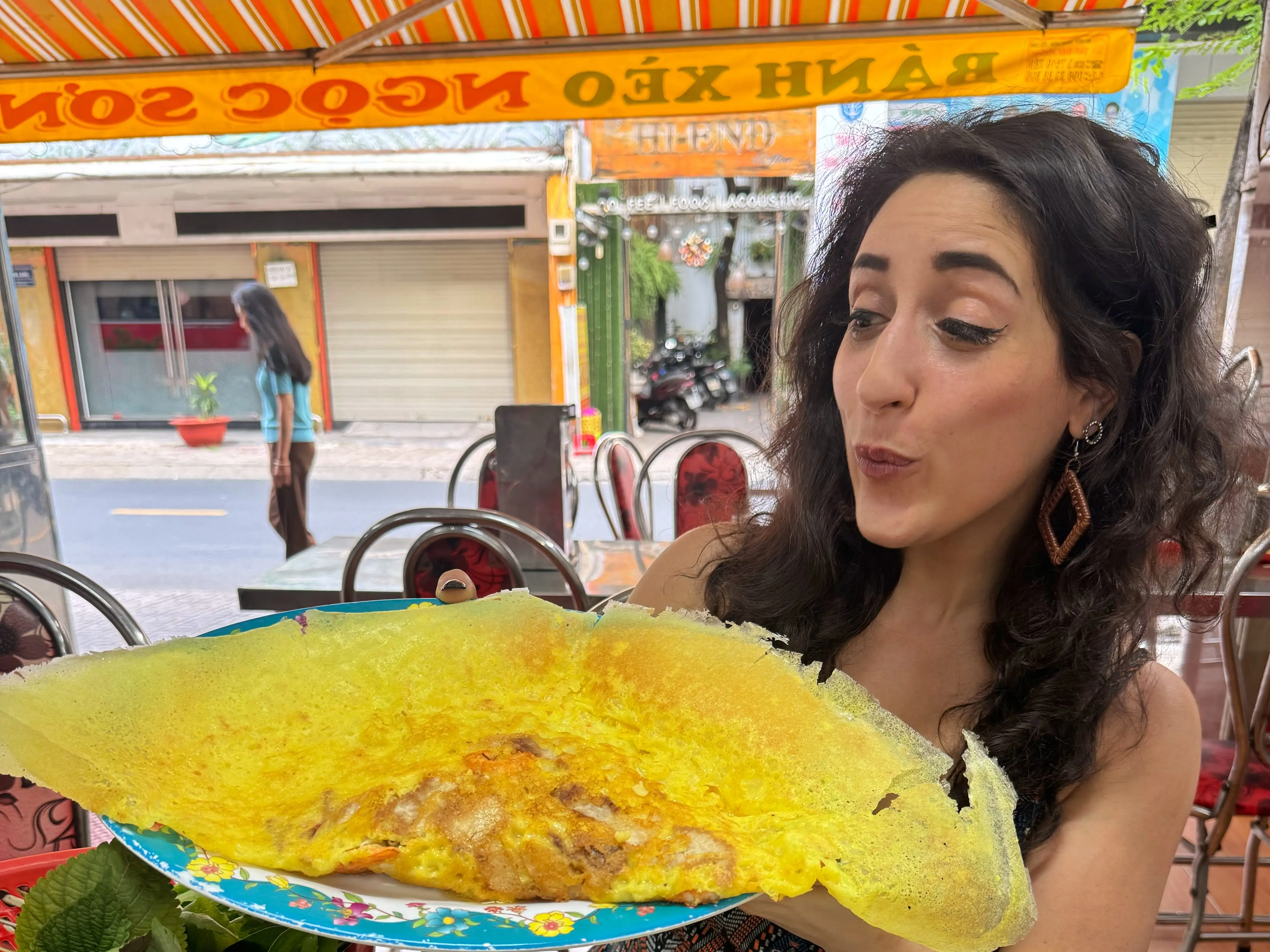 A woman eating banh xeo in Saigon, Ho Chi Minh City, Vietnam.