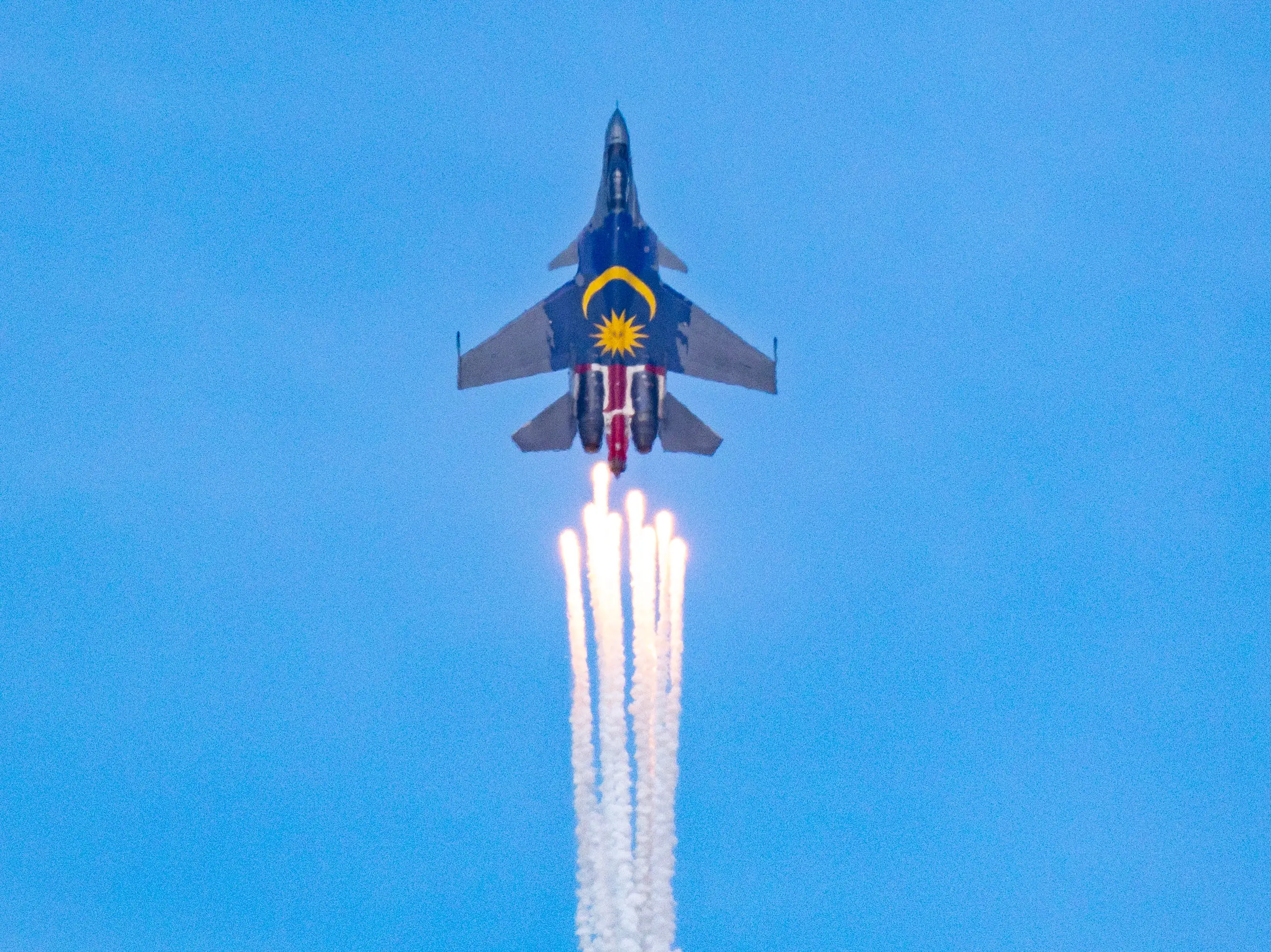 A Su-30MKM disperses flares as it makes a rapid vertical climb.
