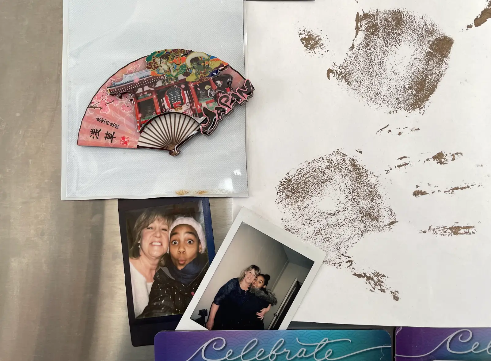 Decorations at the writer's grandparents' house, including a fan from Japan, painted handprints, and Polaroids of the writer.