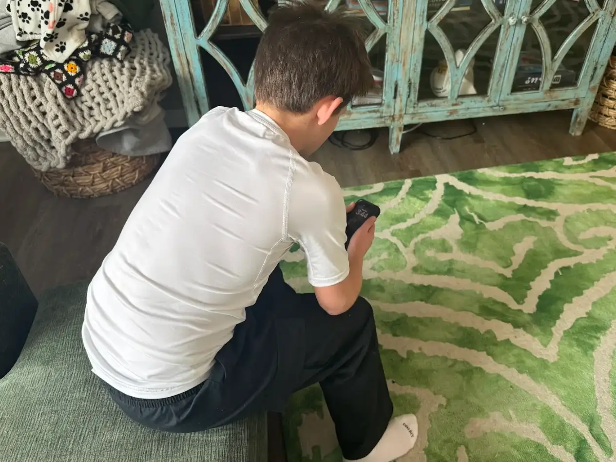 Alexandra Frost's son looking down at his cellphone