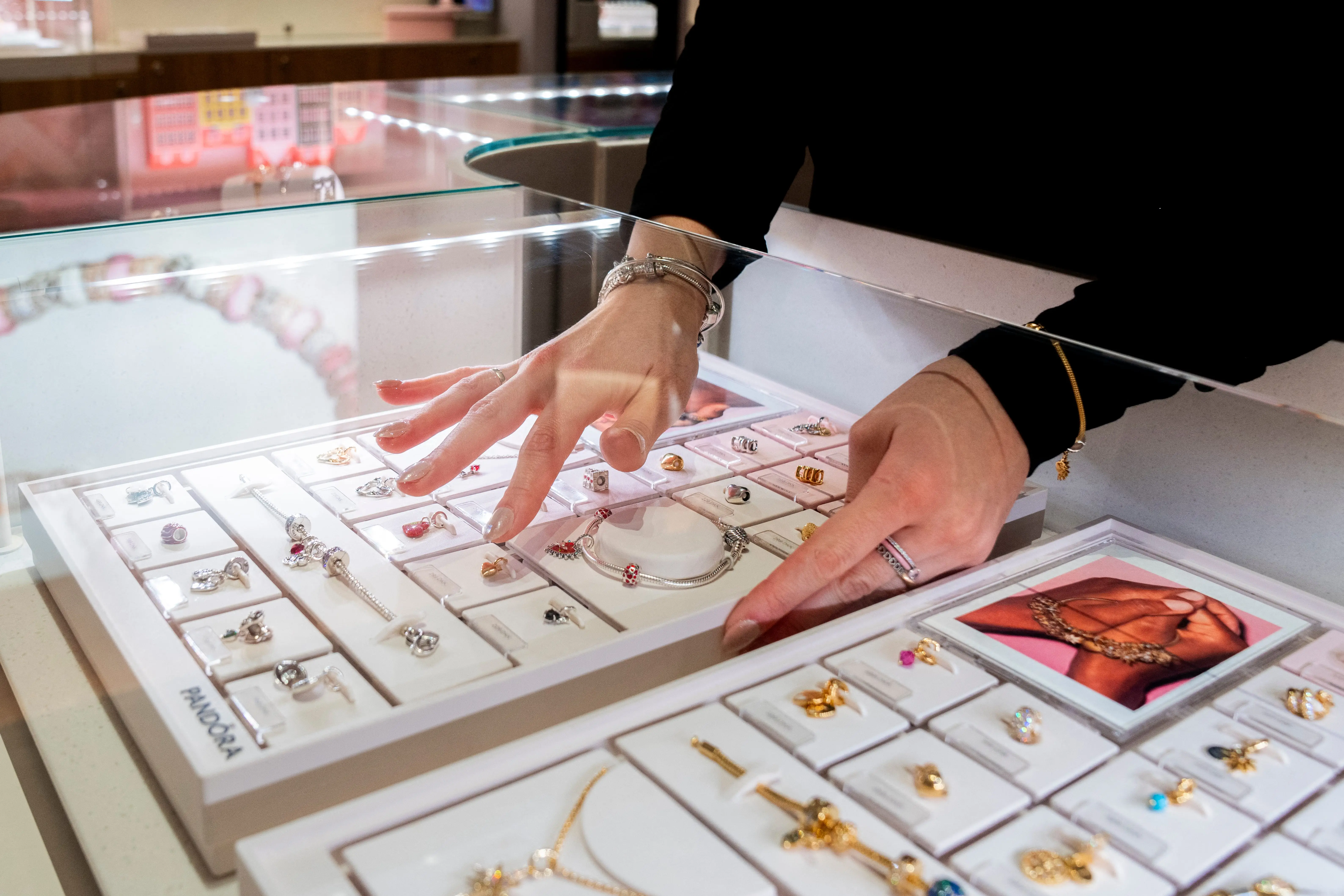 A woman arranges jewellery inside a store of Danish international jewellery company Pandora in Copenhagen, Denmark, on January 27, 2025.