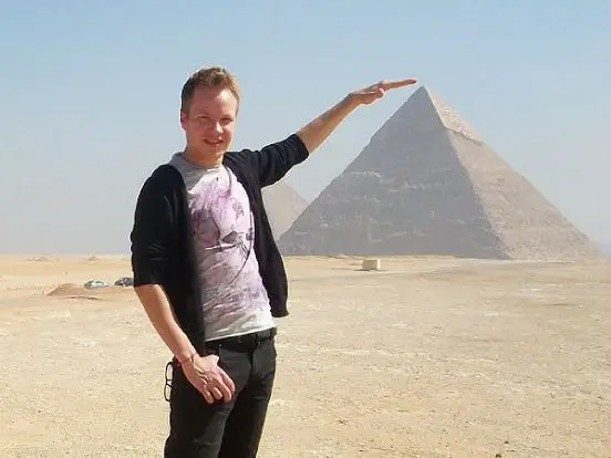 A man standing next to the pyramids in Cairo, Egypt,