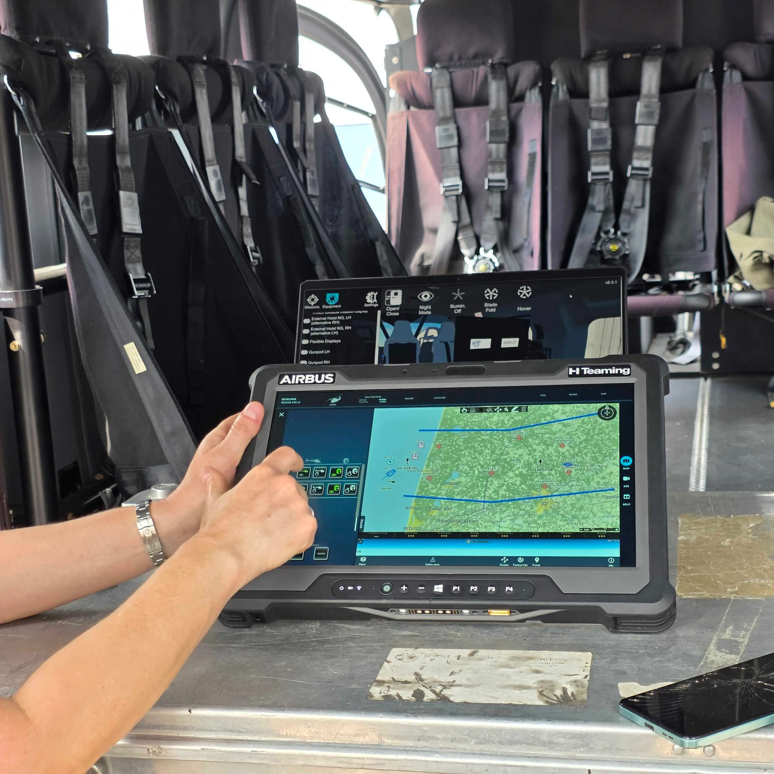 An Airbus employee holds the HTeaming tablet in the back of a helicopter.