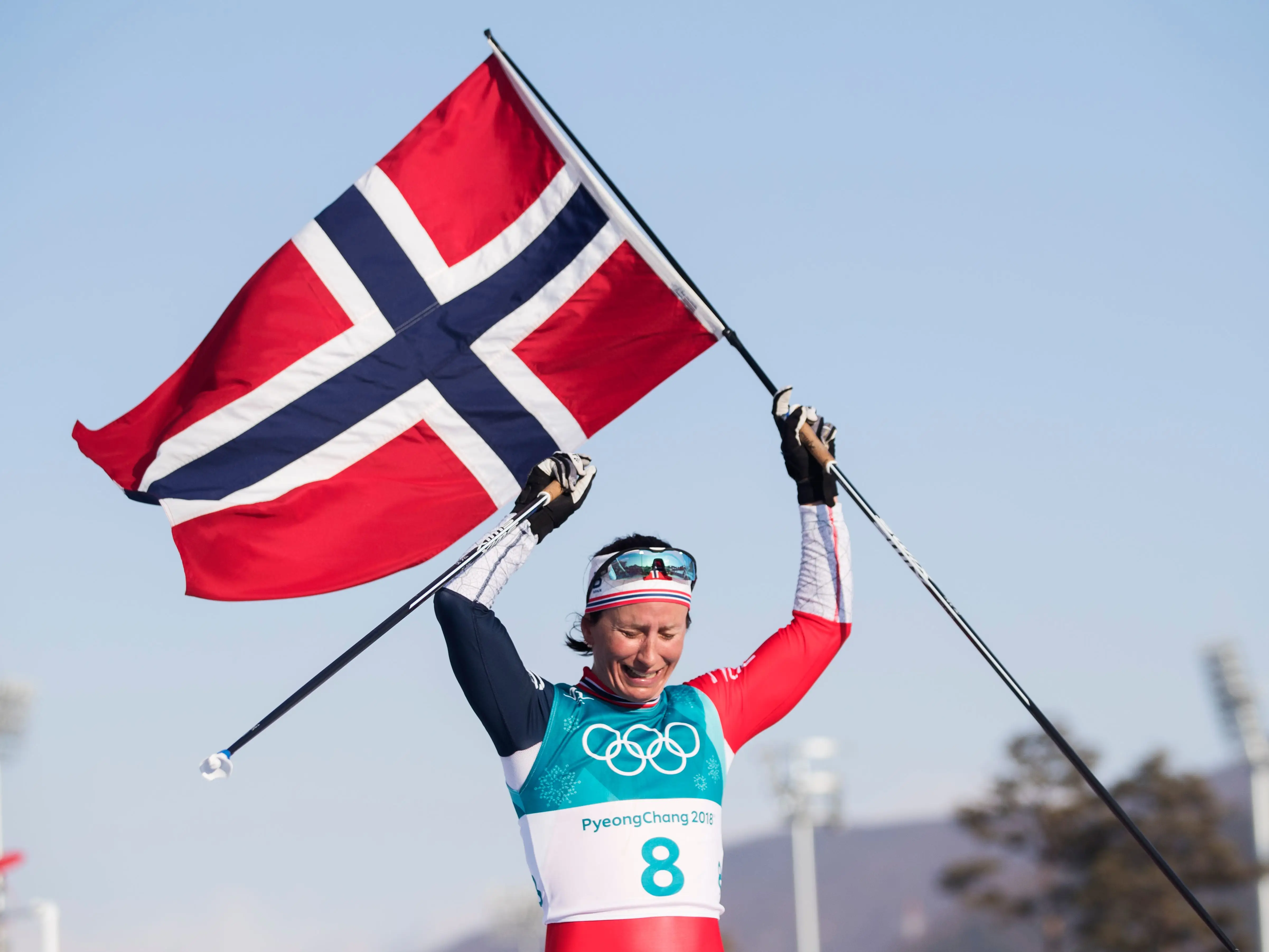 Marit Bjørgen celebrated her gold medal win in the women's 30-kilometer cross-country ski race, raising the Norwegian flag and her ski poles with her head hung with tears.