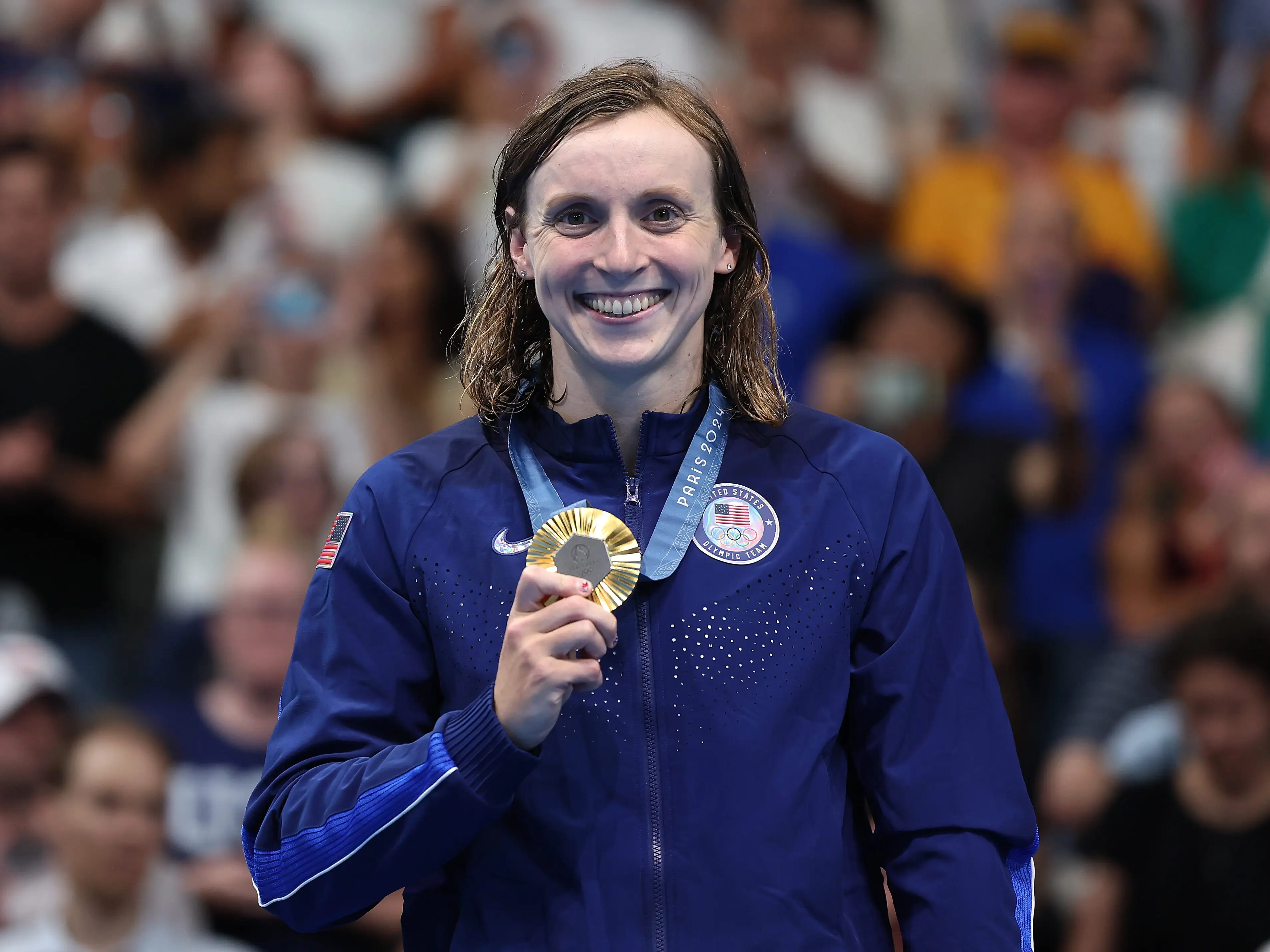 Katie Ledecky of the United States smiled and held her gold medal atop the podium after winning the women's 800-meter freestyle at the 2024 Olympics.