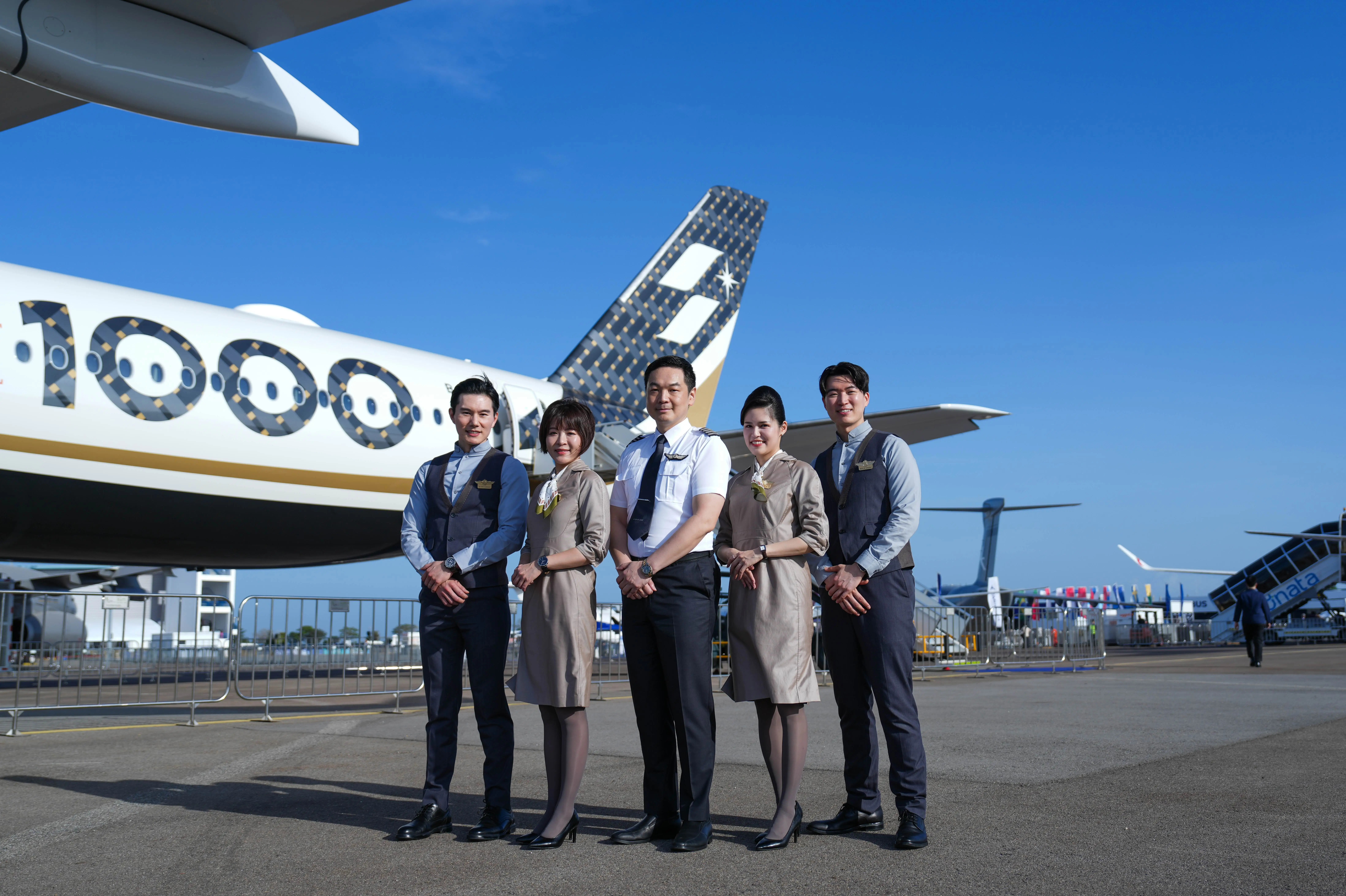 Cabin crew and a pilot pose in front of the Starlux Airlines' new A350-1000.
