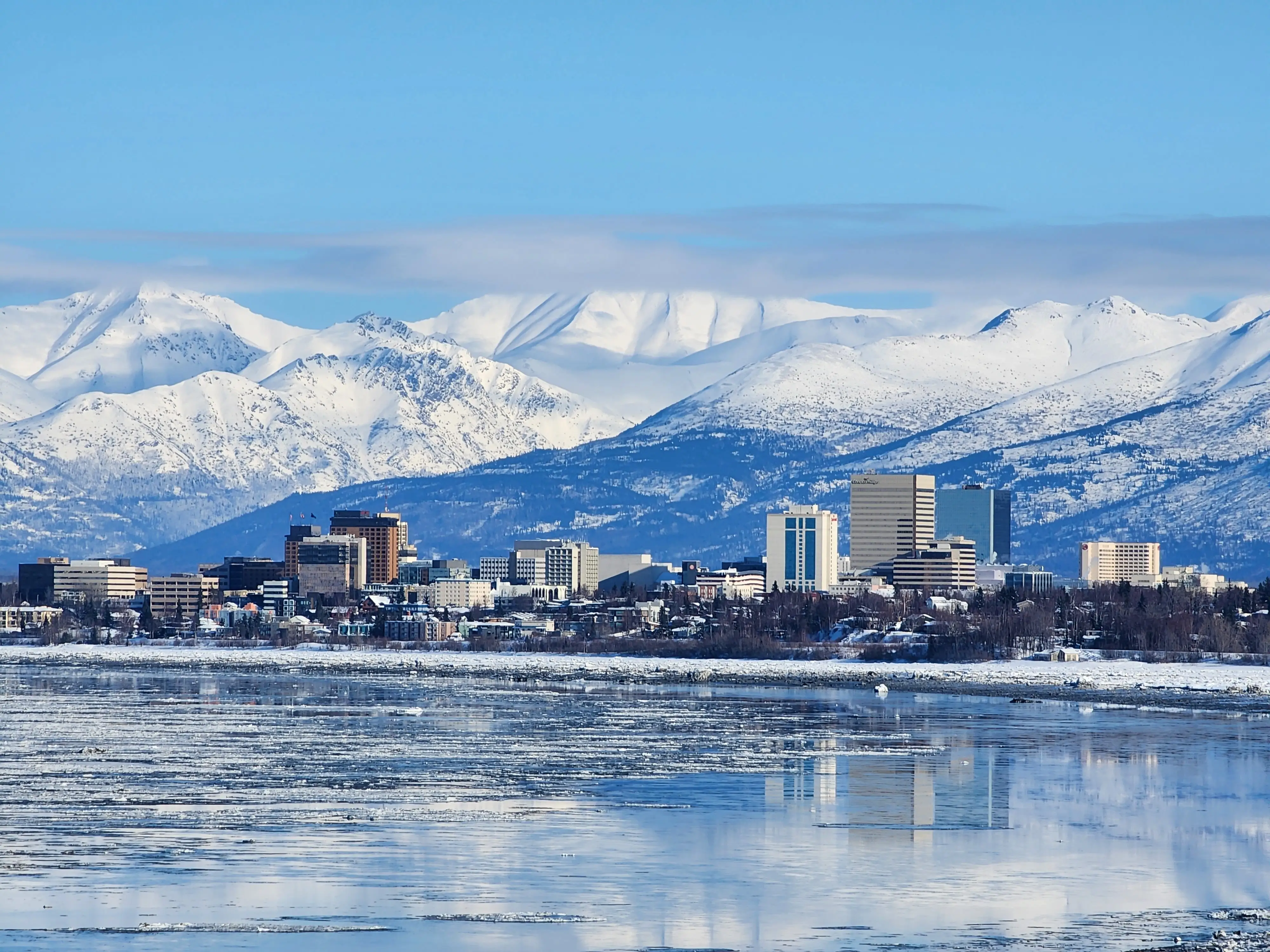 Buildings in Anchorage, Alaska next to snowy mountains.
