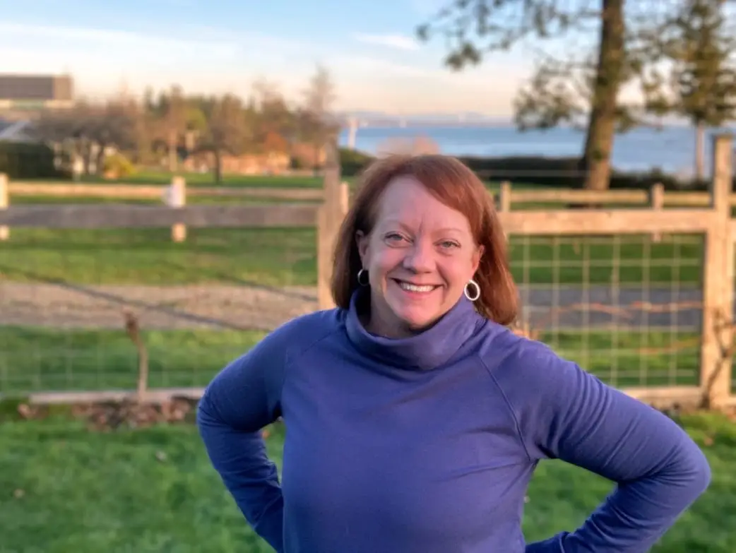 Woman smiling in front of fence