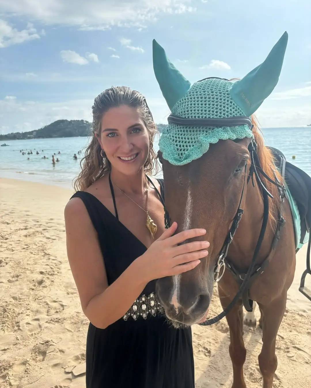 Cheska Hull stroking a horse on a beach in Phuket, Thailand.