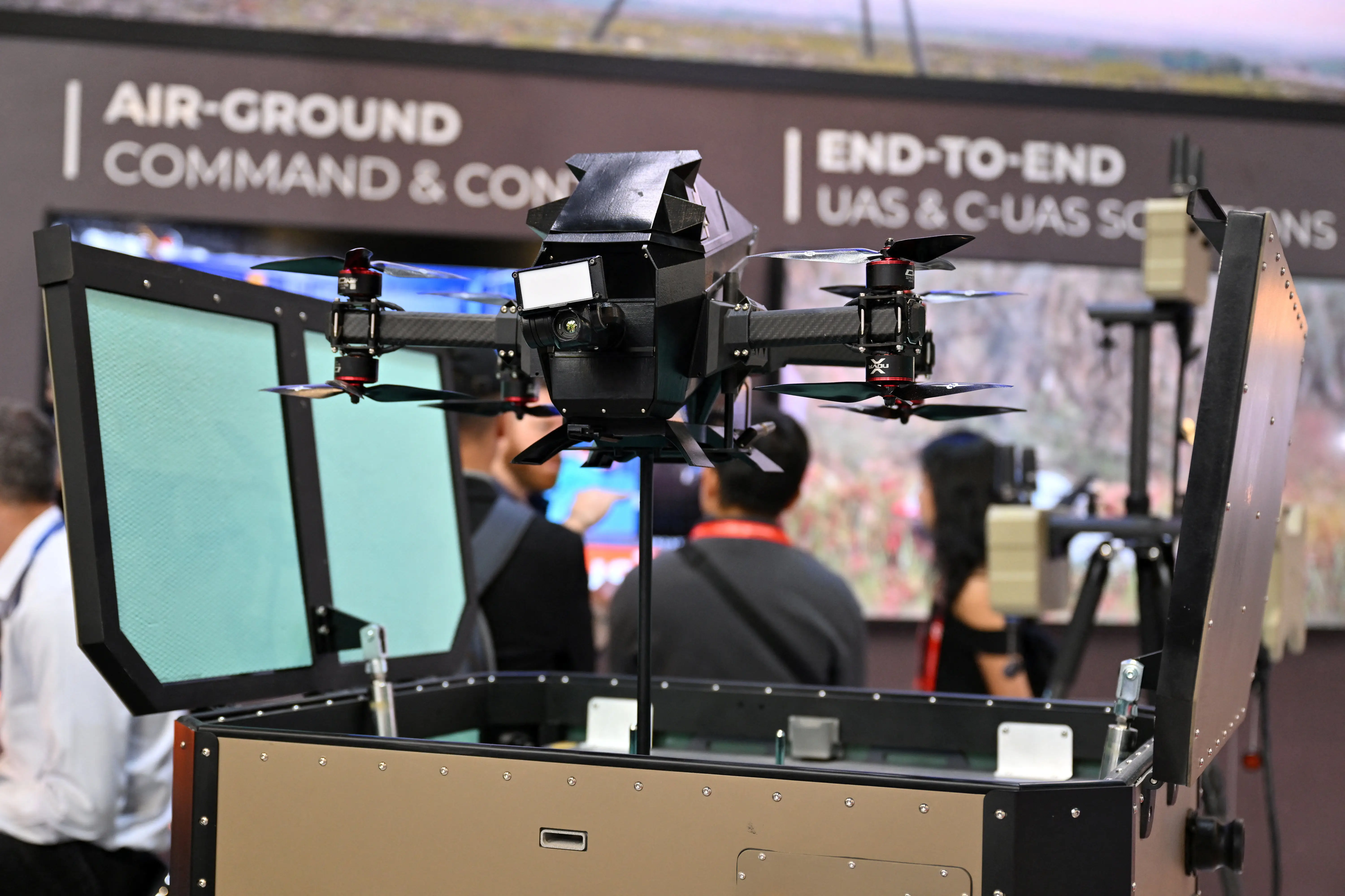 A quadcopter is seen mounted on an open box.