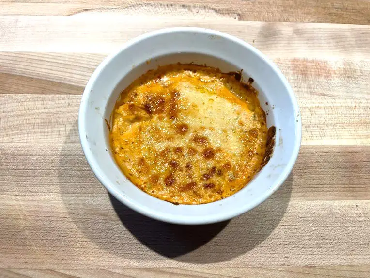 A small bowl of Buffalo-chicken dip with a golden-brown, bubbled-up cheesy surface.