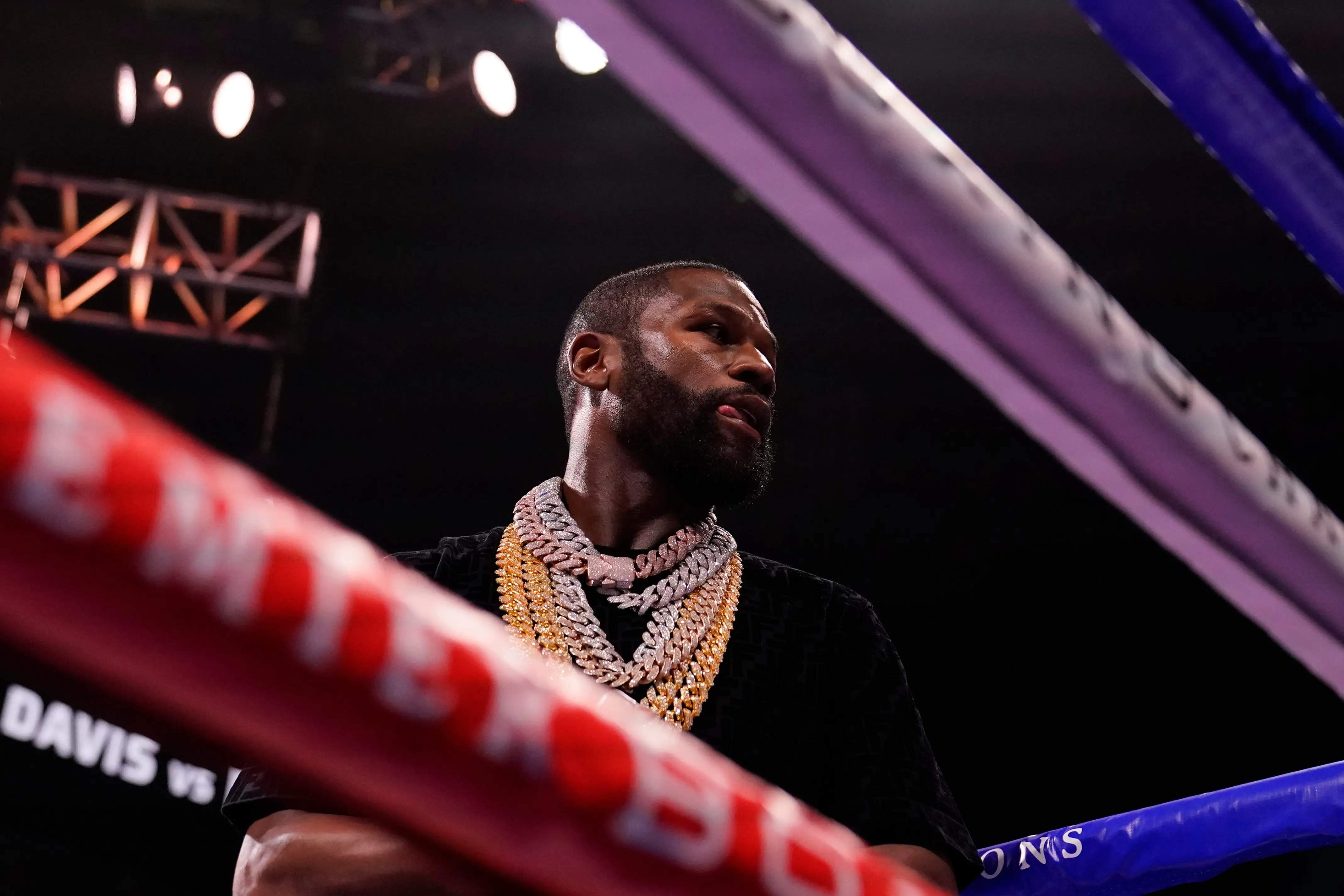 Floyd Mayweather in a boxing ring wearing gold jewelry