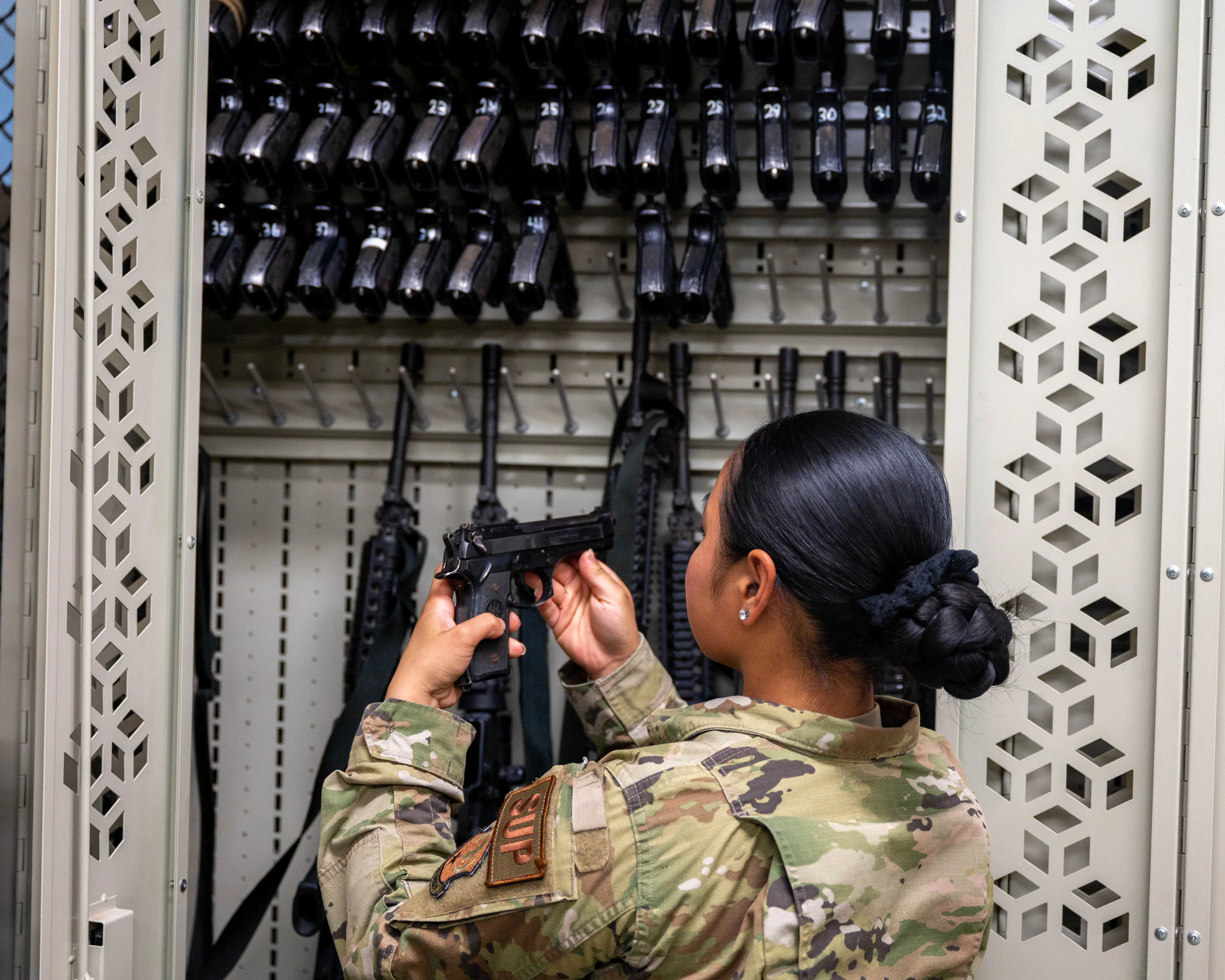 An Air Force supply specialist examines a pistol serial number during a weapons inventory at Camp Lemonnier, Djibouti, July 10, 2024.