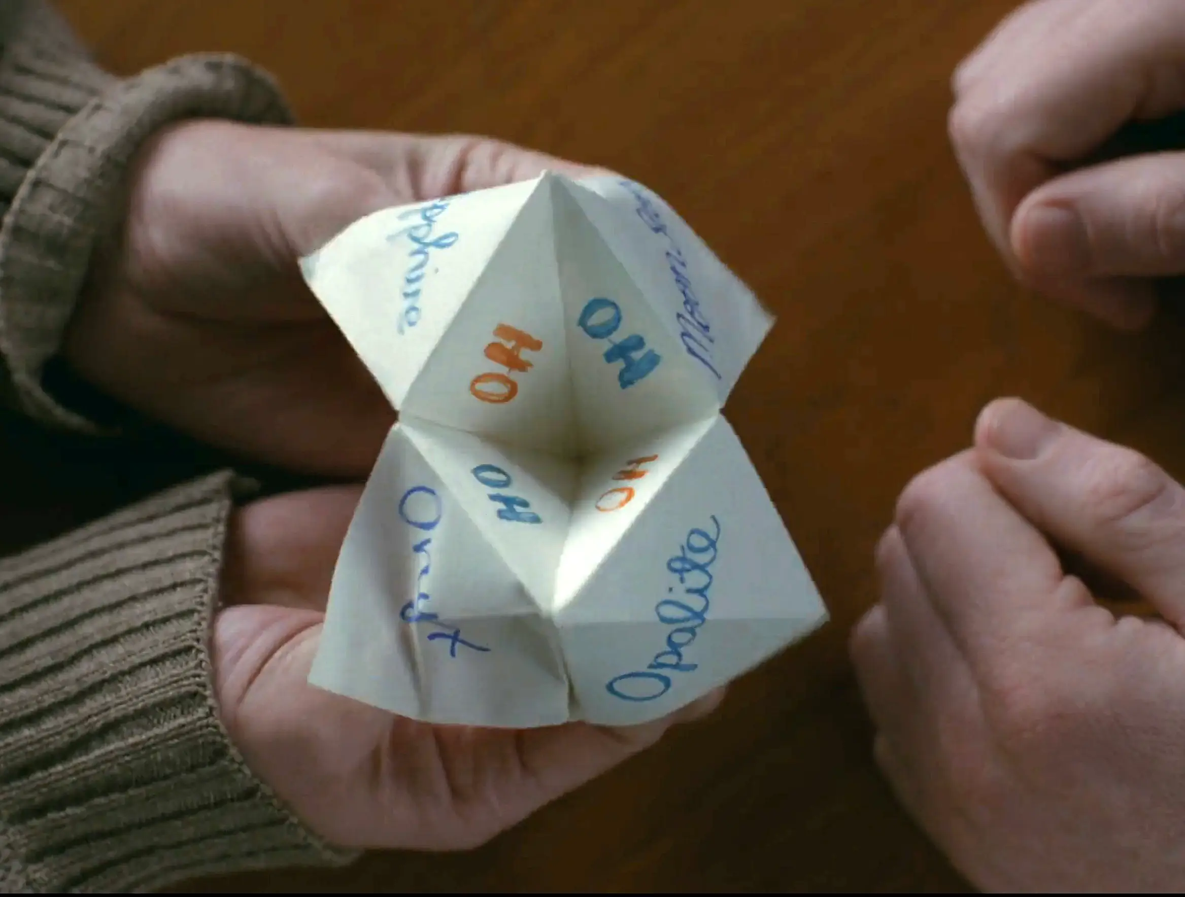 Taylor Swift folds a paper fortune teller in the 