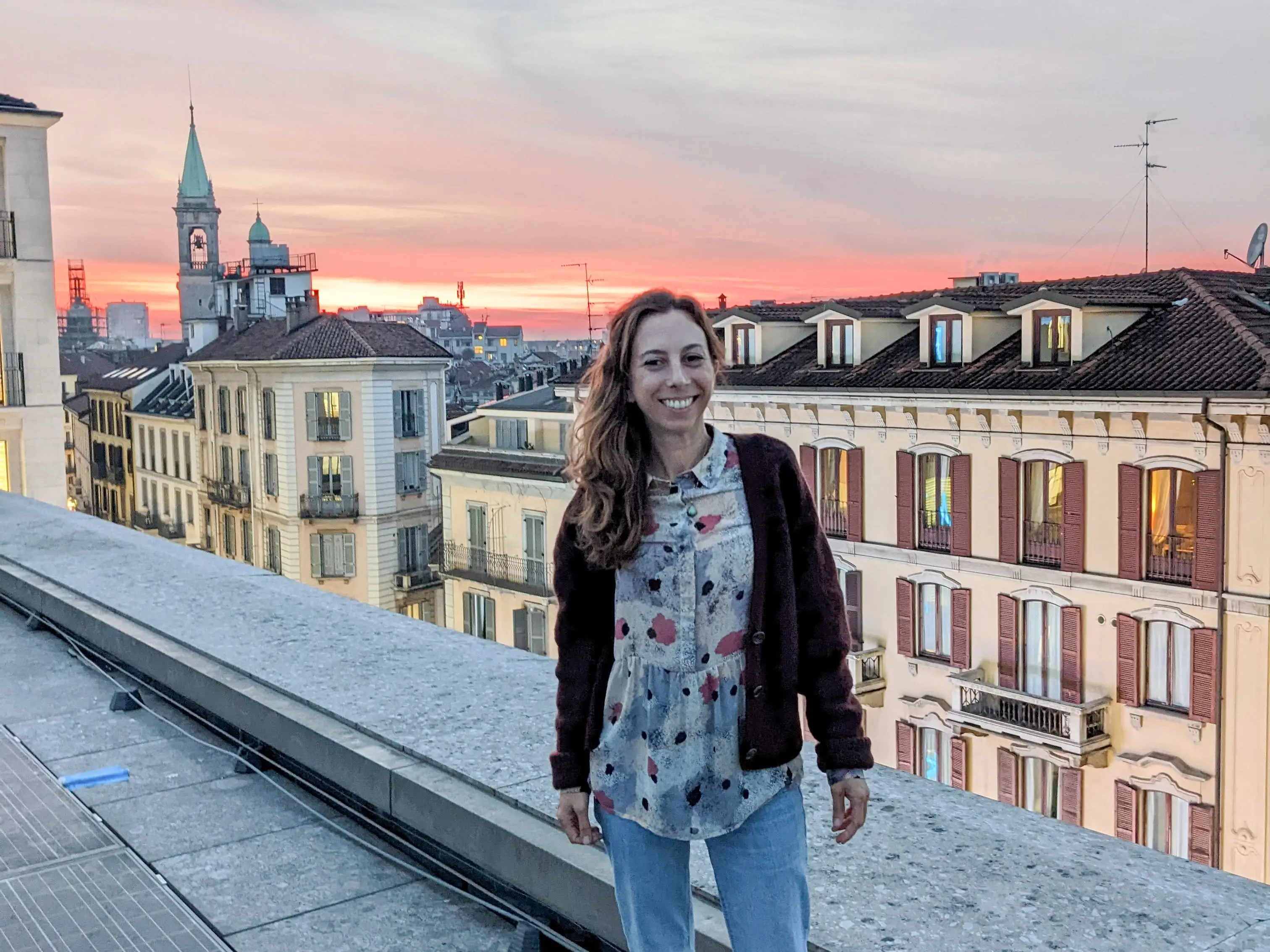 Liz stands on a rooftop at sunset in Milan.