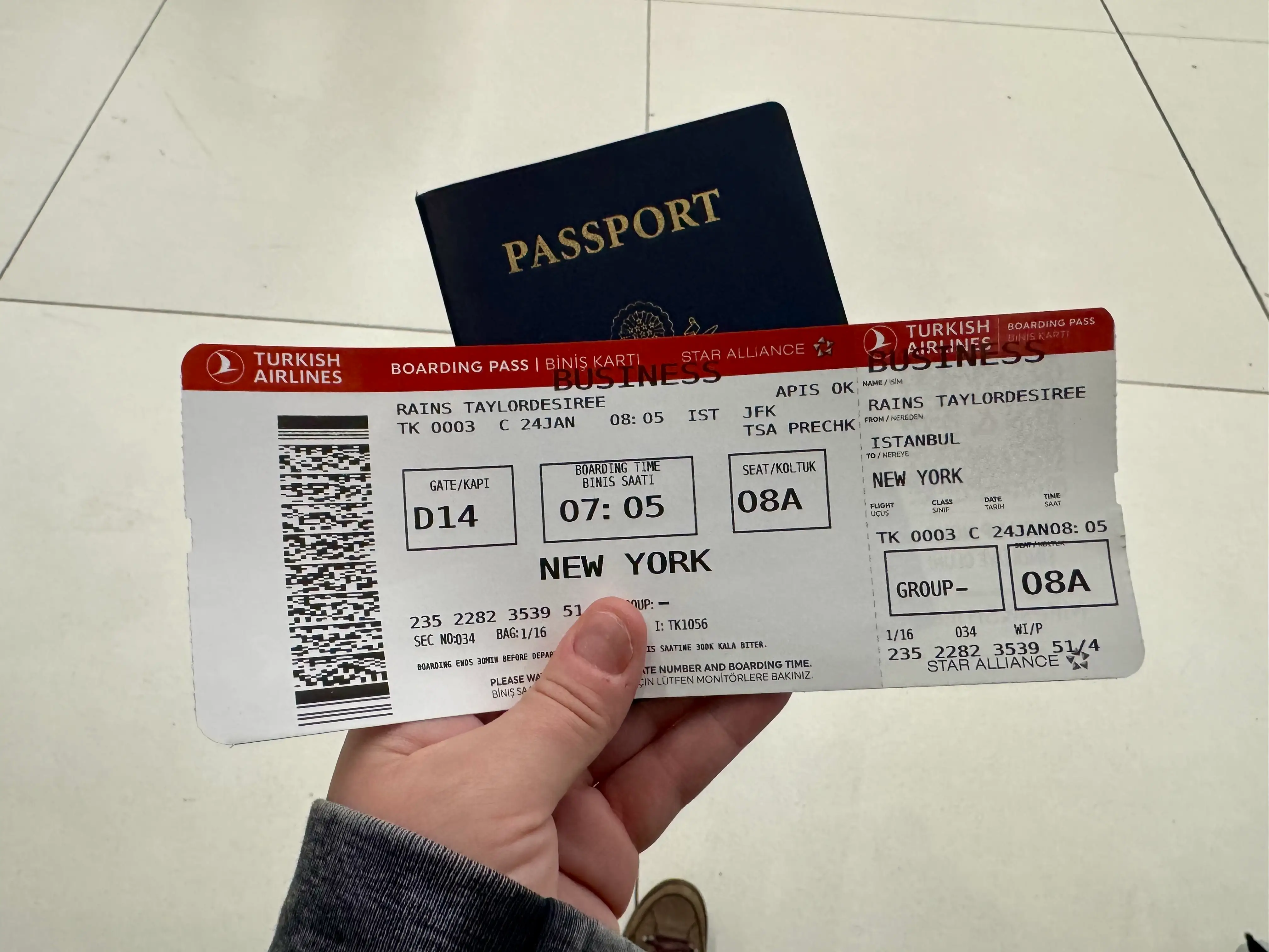 Author holding her boarding pass and passport.