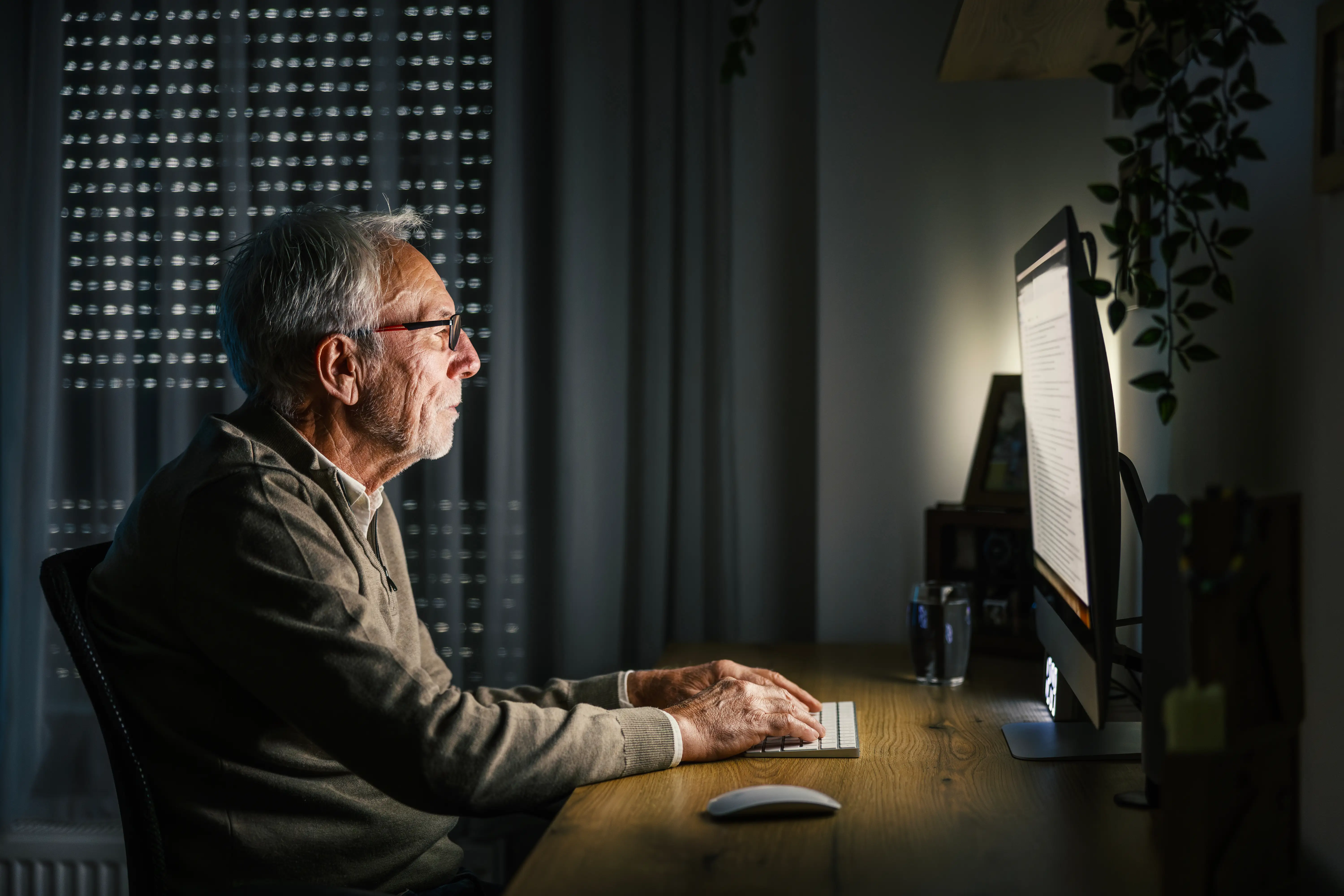 older man playing computer games late night