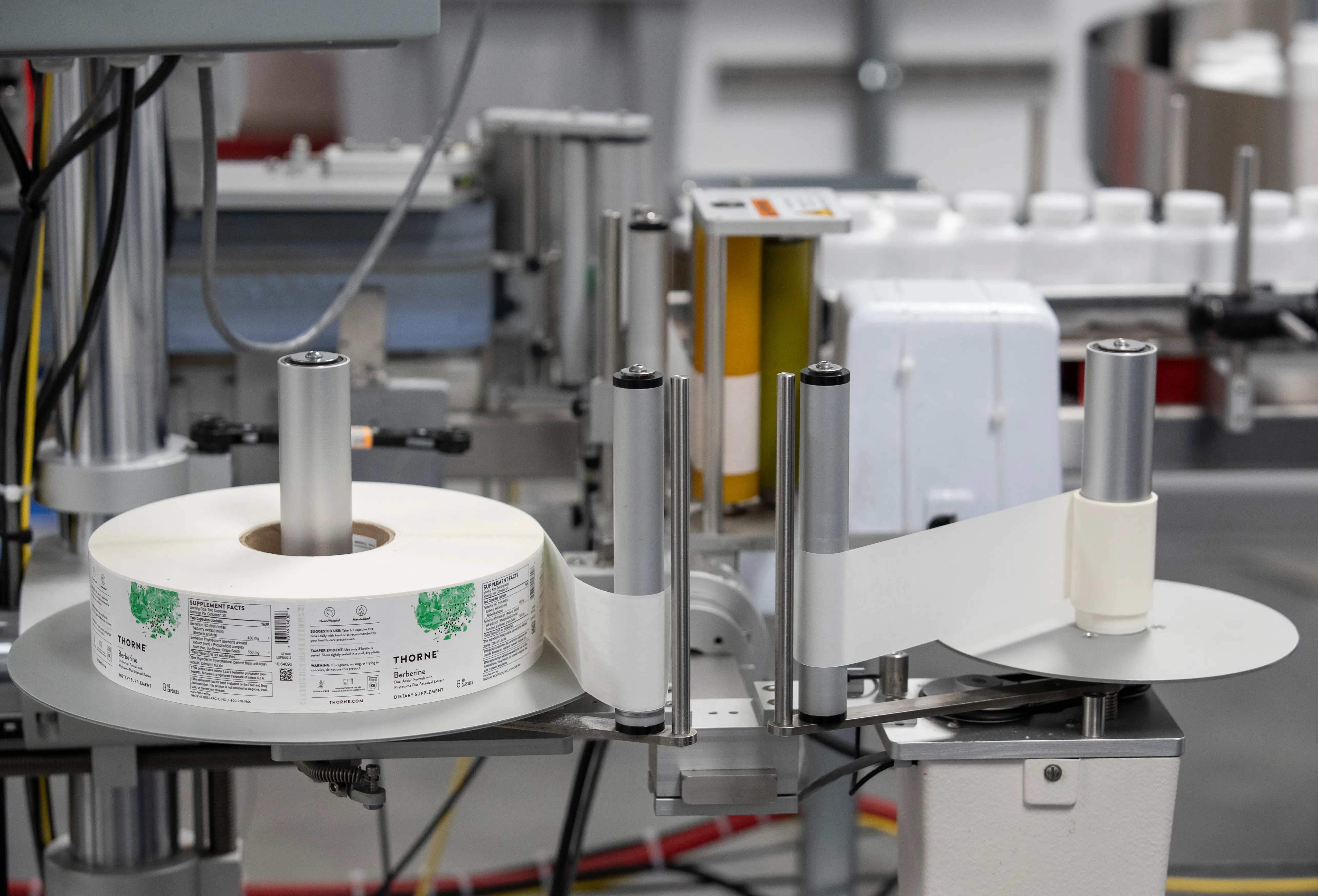 A roll of labeling tape winds through a machine for application onto bottles at the Thorne manufacturing facility, Friday, September 5, 2025, in Summerville