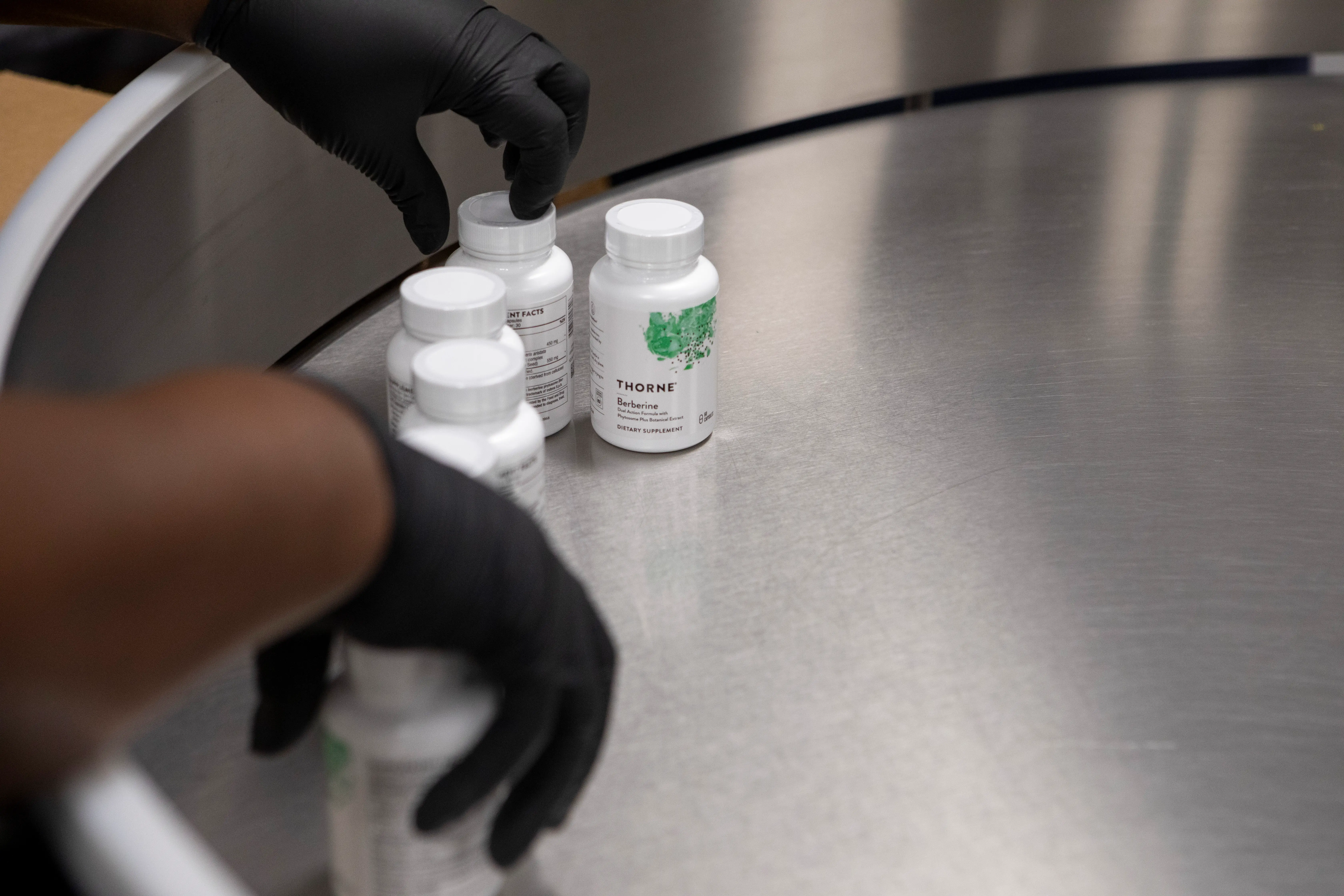 A worker grabs freshly sealed and labeled bottles of Thorne supplements at their manufacturing facility, Friday, September 5, 2025, in Summerville.