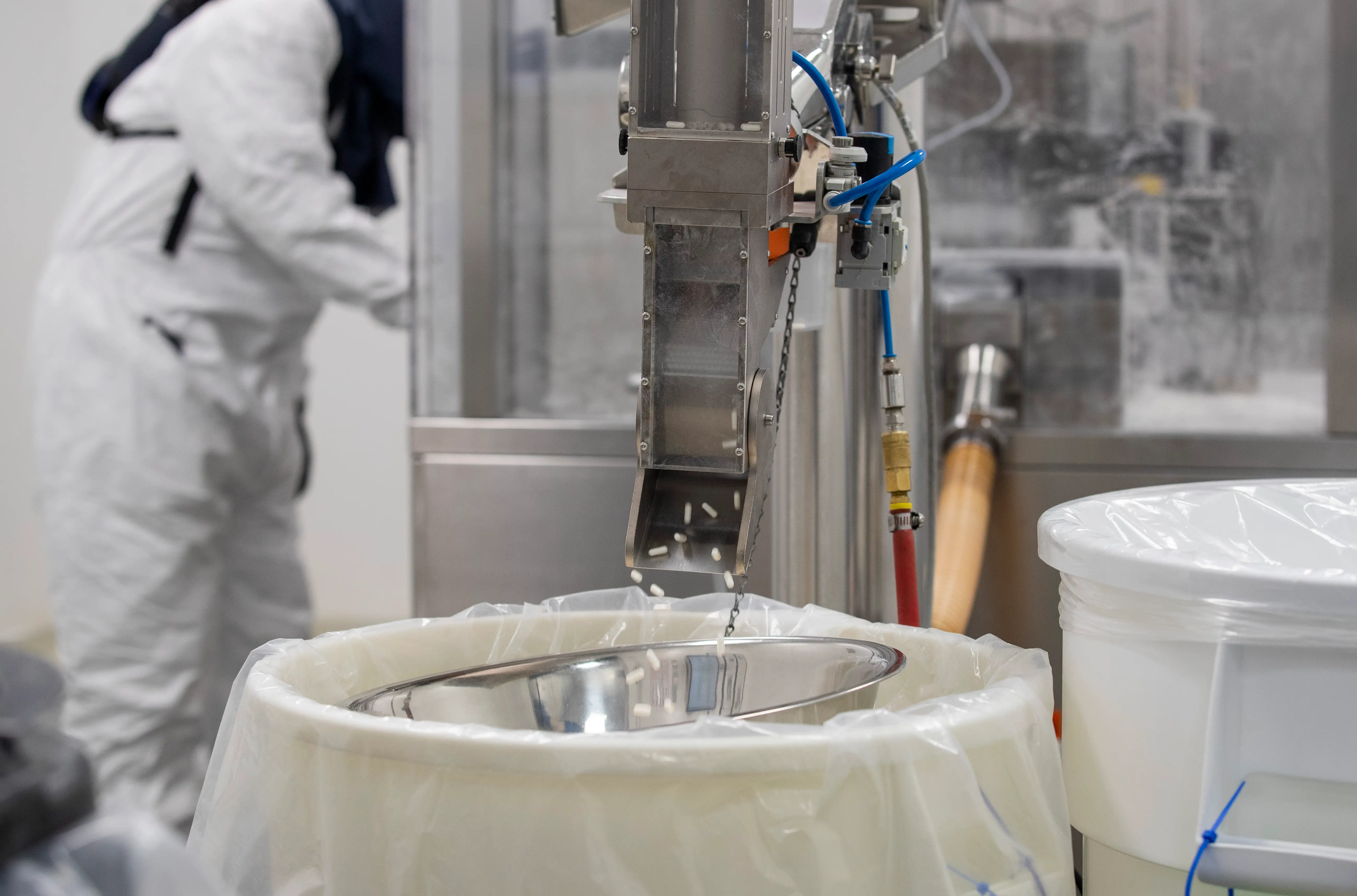 Manufactured pills shower down from a machine into a tub before the next packaging stage at the Thorne manufacturing facility, Friday, September 5, 2025, in Summerville.