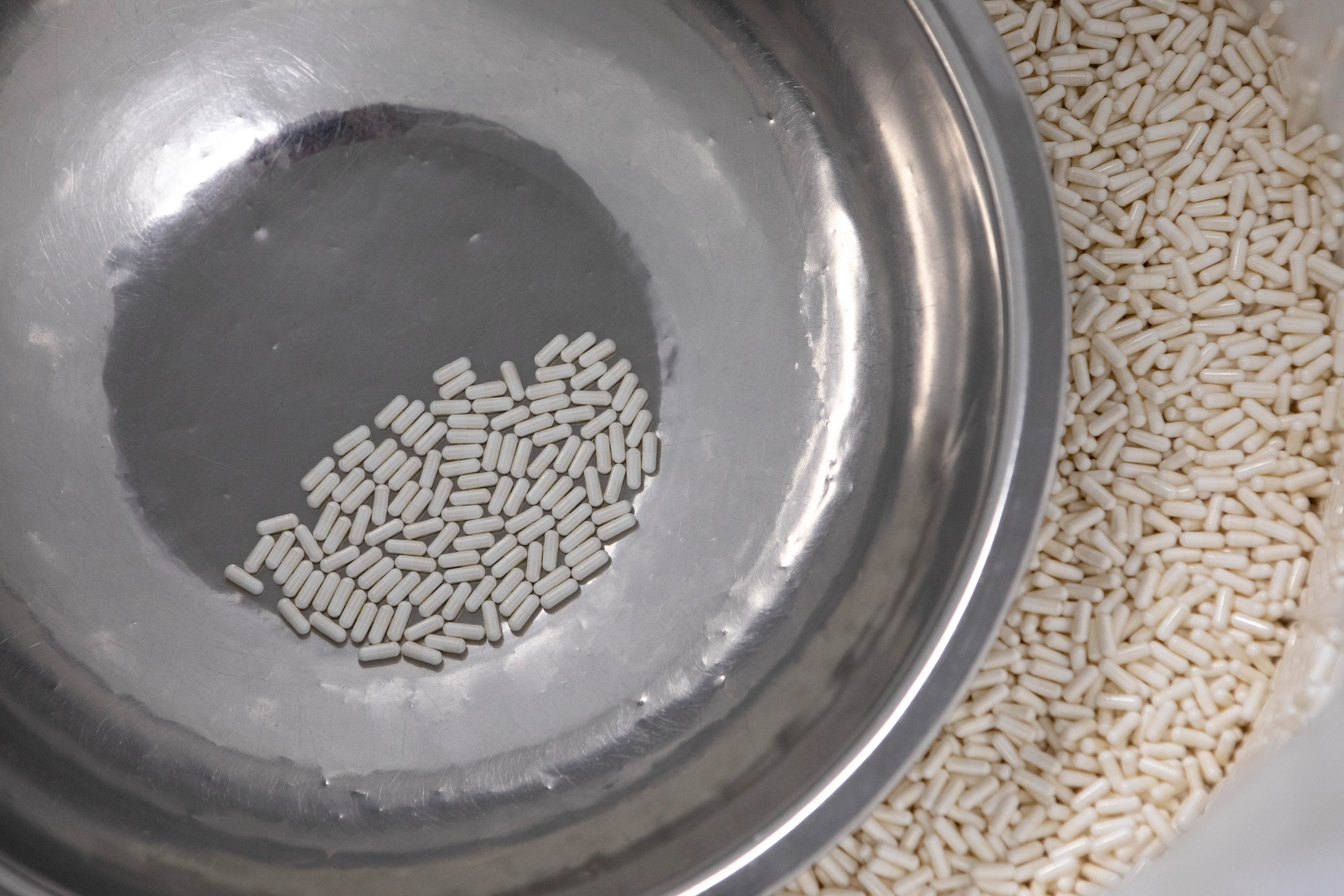 Capsules to be sorted into bottles for packaging sit in a large bucket on the manufacturing line, Friday, September 5, 2025, in Summerville.