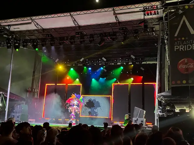 Rainbow-colored spotlights shining on performer on a stage
