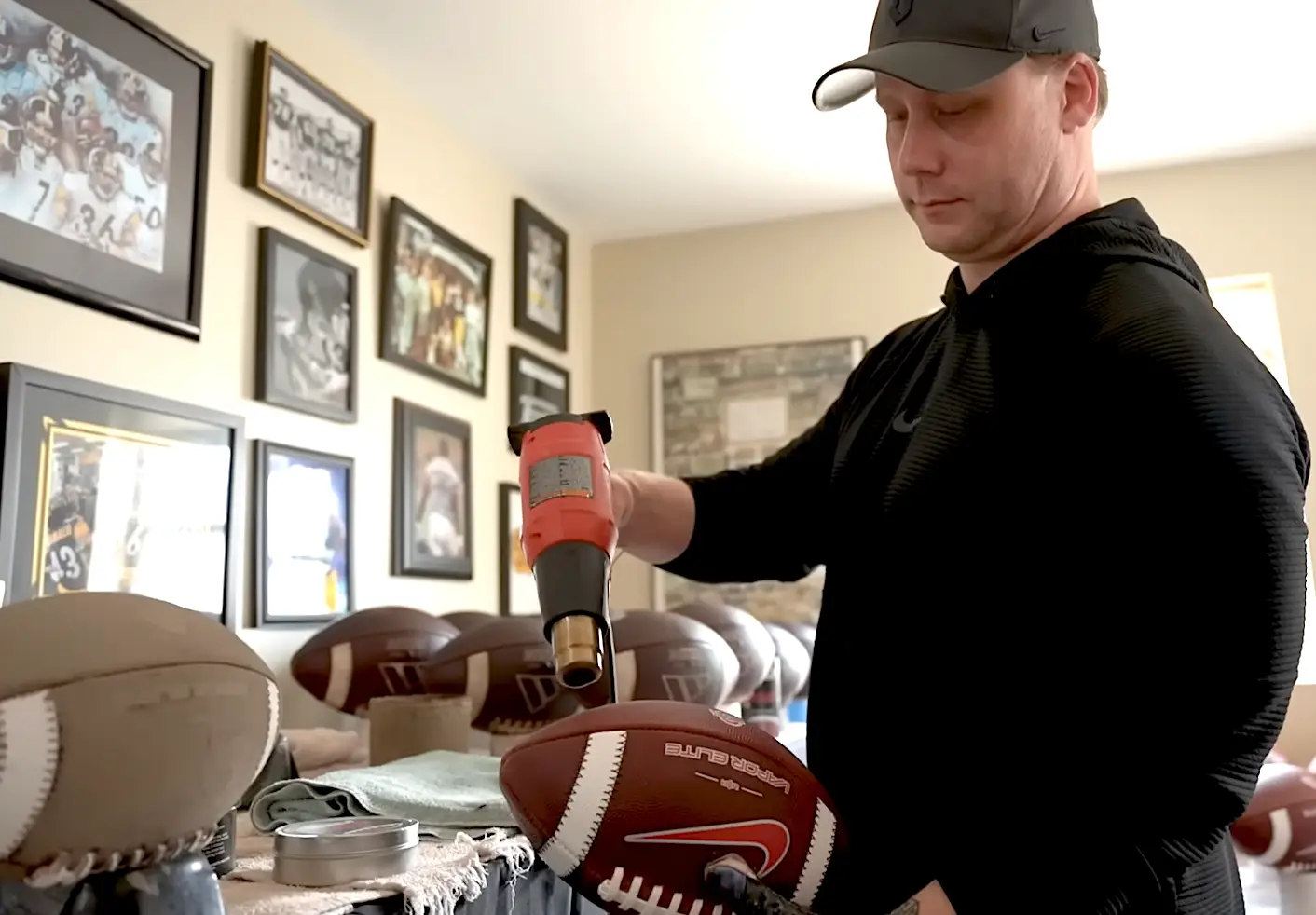 Daniel Kolcun prepping a football in his home for his business.