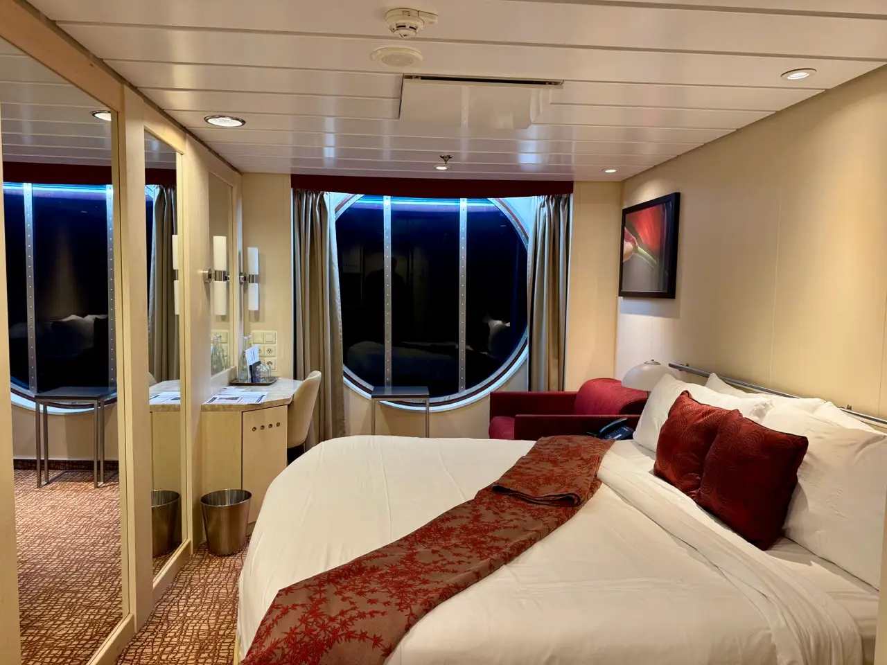 Large window in deluxe ocean view cabin next to bed on Celebrity Constellation