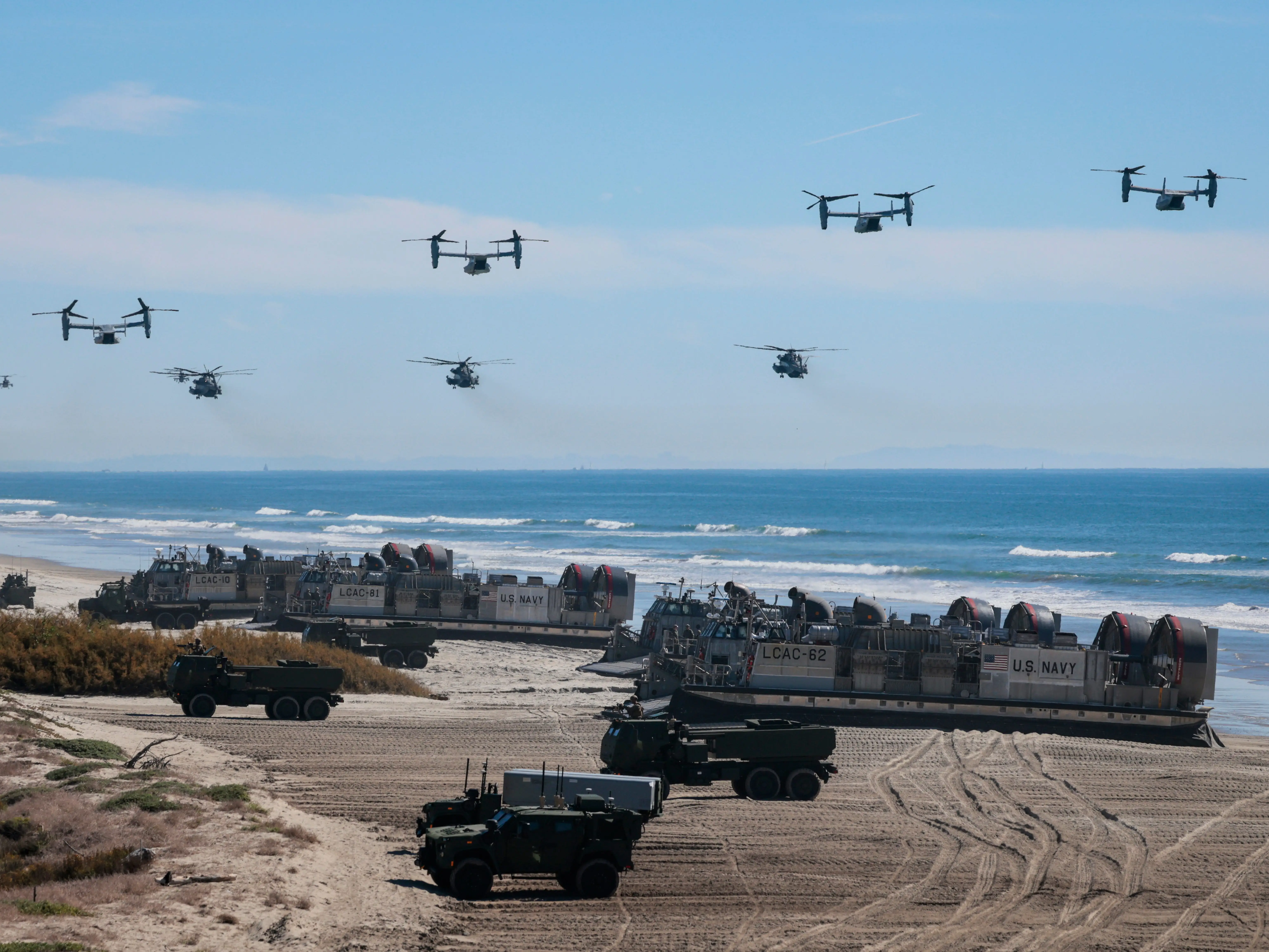 U.S. Navy Landing Craft Air Cushion's (LCAC) unload equipment onto the beach as U.S. Marine Corps V-22 Ospreys and CH-53 Super Stallions fly overhead during the America's Marines 250 event at Camp Pendleton's Red Beach on October 18, 2025 in Oceanside, California. The U.S. Marines are marking their 250th anniversary with a live amphibious assault demonstration entitled 