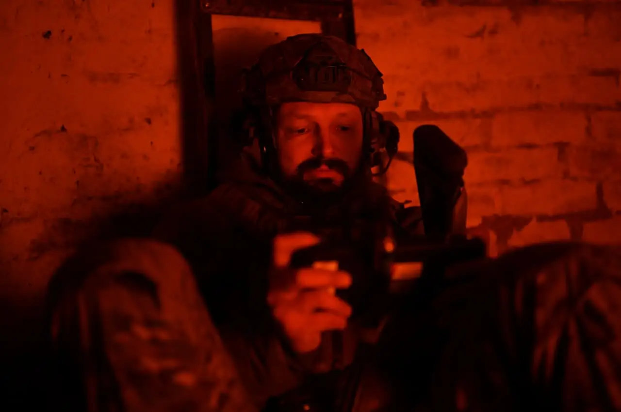 Serhii Andrieiev uses a drone remote control as he sits inside a shelter.