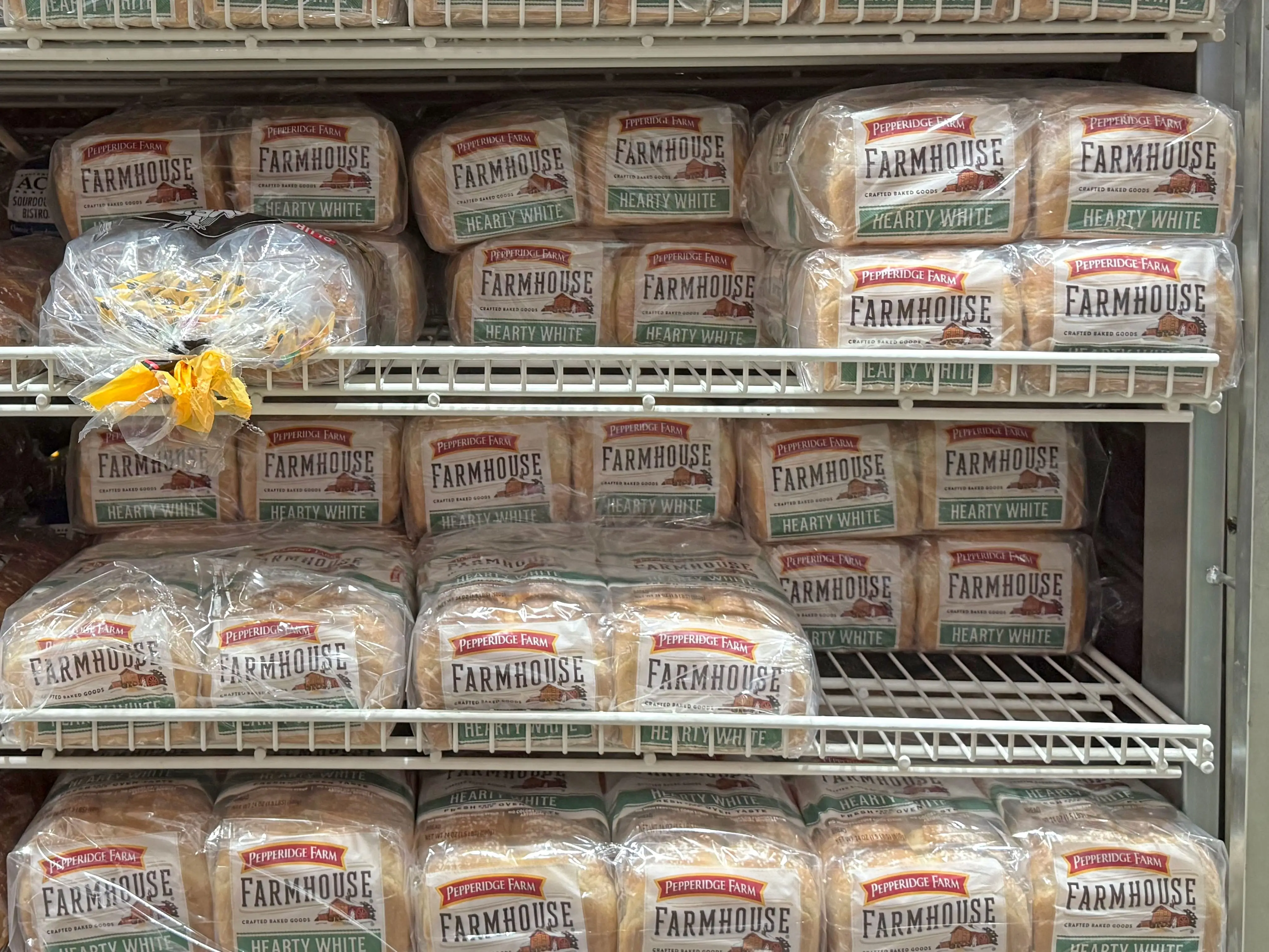 Loaves of Pepperidge Farm white bread on shelves at Costco.