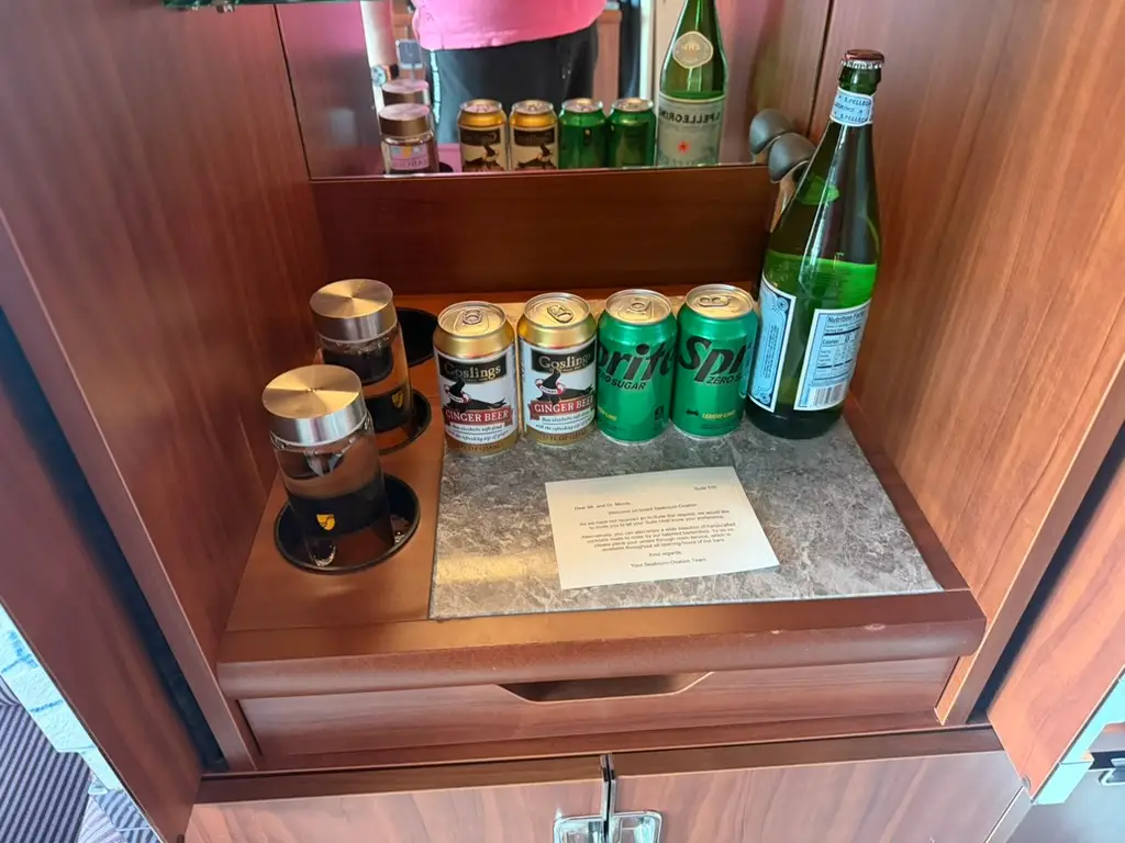 Top of mini fridge with canned drinks, bottle of water
