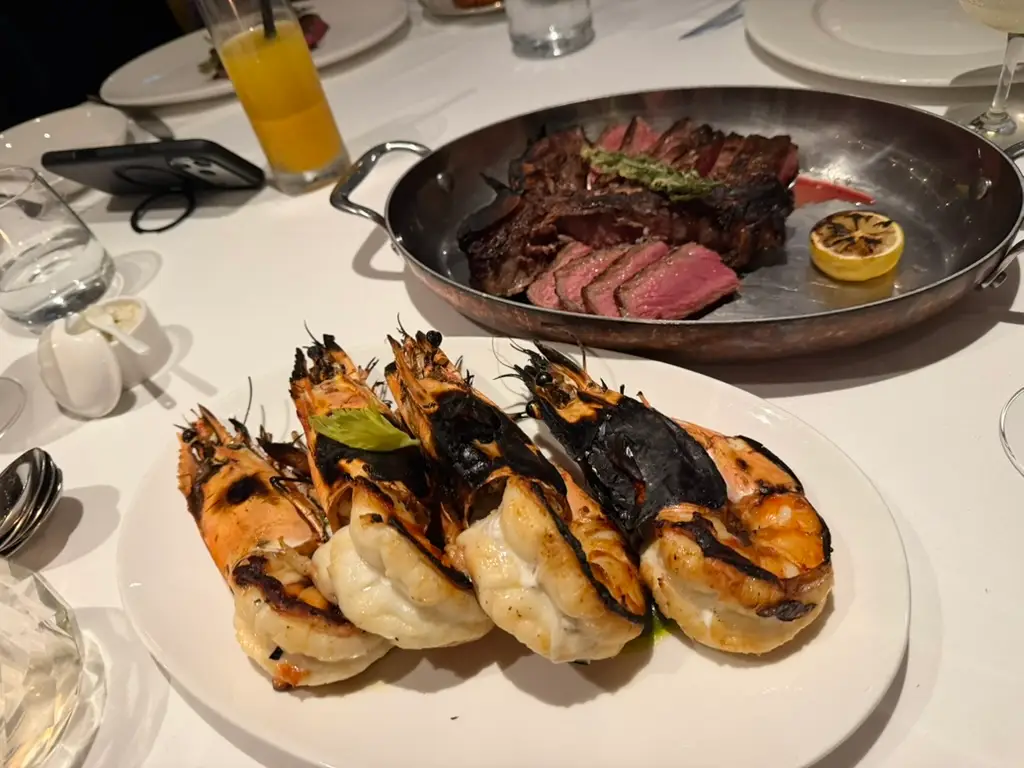 Charred seafood and steak in plates