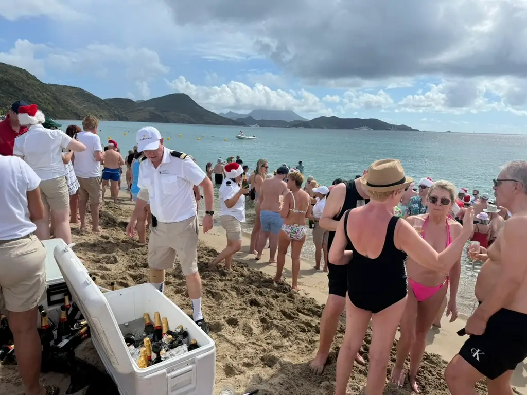 People in sand on beach with cooler of drinks