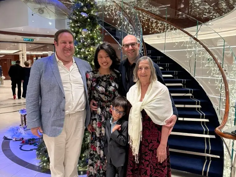 Group of people dressed up, posing by stairs on cruise ship