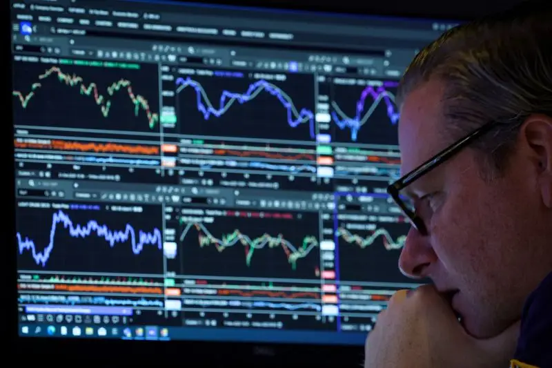 A Wall Street trader works inside a booth on the floor at the New York Stock Exchange (NYSE) in New York City.