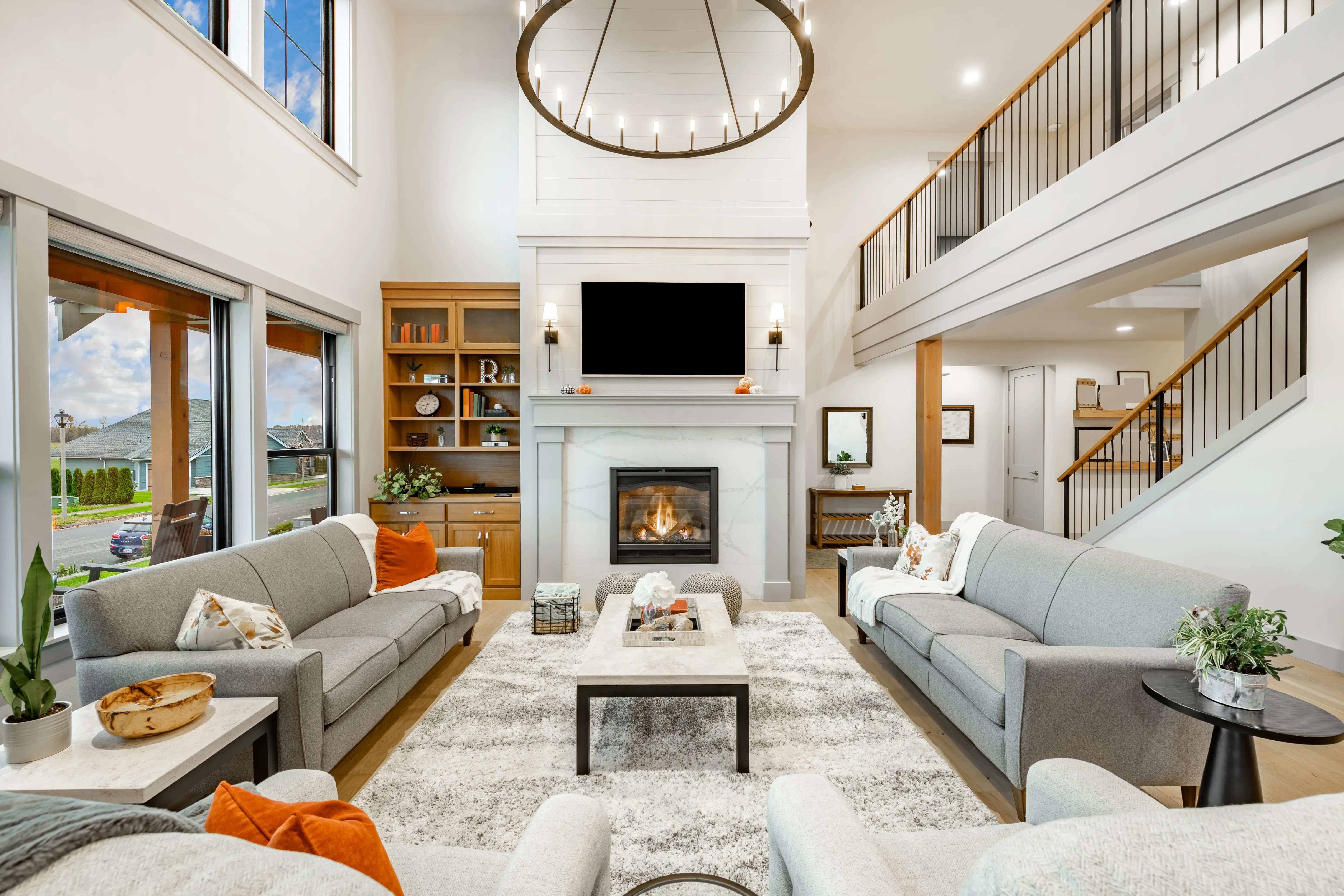 Living room with gray and white couches, TV abovefireplace